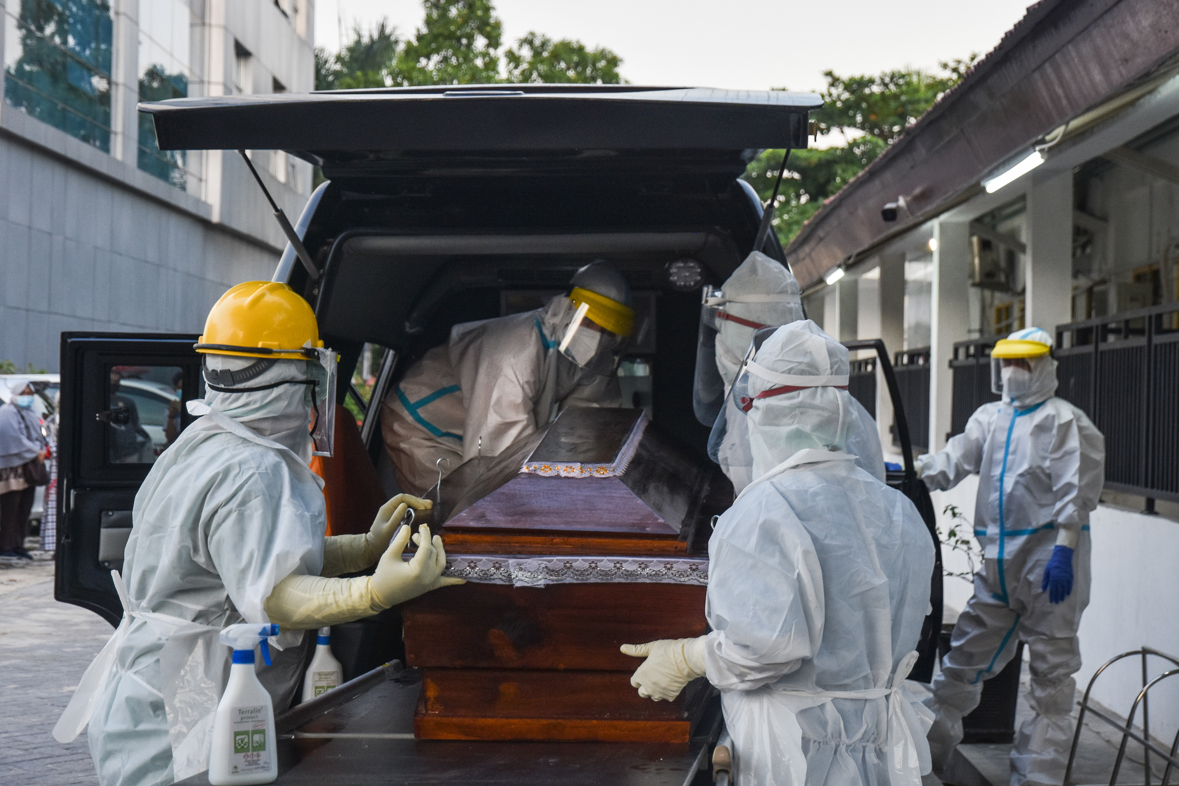 DOKTER WAFAT: Tenaga kesehatan memasukkan peti berisi jenazah almarhum dokter Jhon Andi Zainal yang meninggal akibat covid-19 di Riau