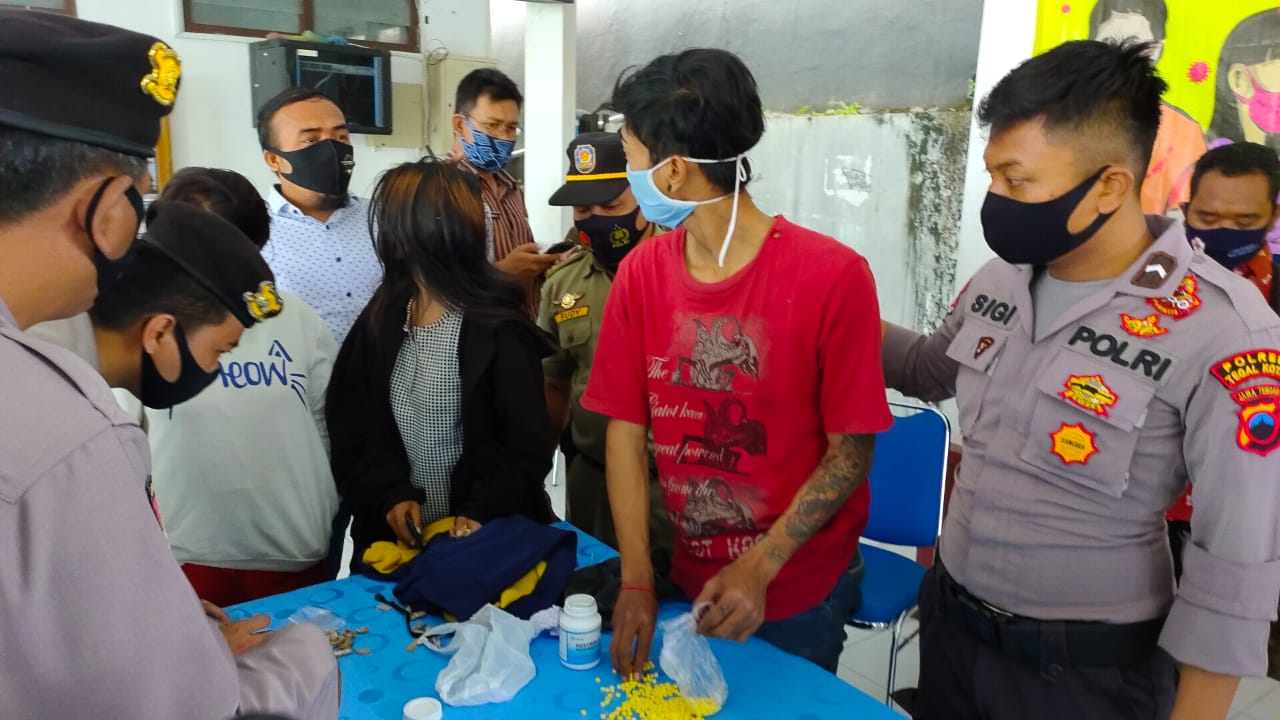 Johan (kaos merah) dengan barang bukti 400 butir pil koplo di Mapolres Tegal, Selasa (6/10/2020).