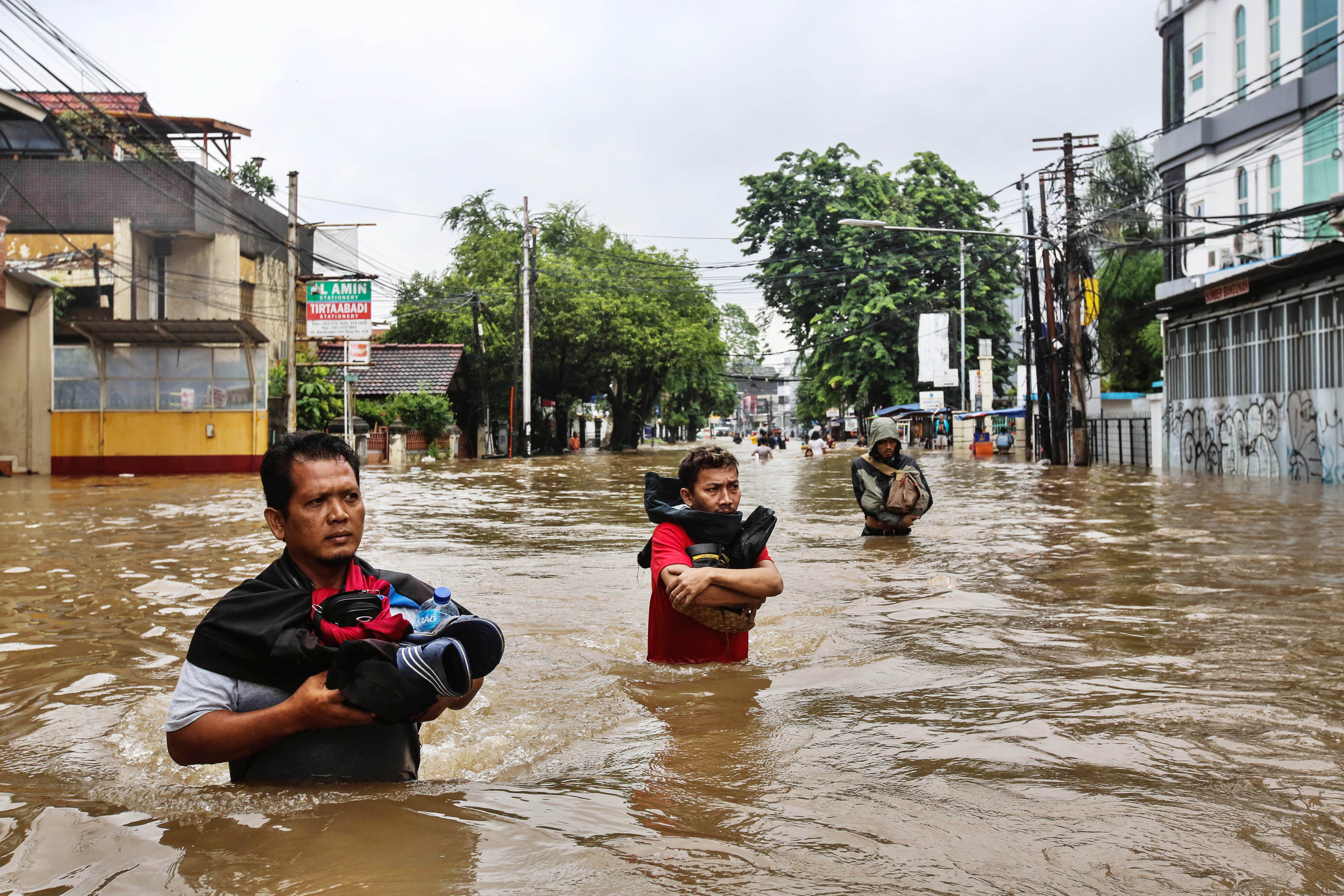Warga melewati banjir yang menggenangi kawasan Benhil, Jakarta.