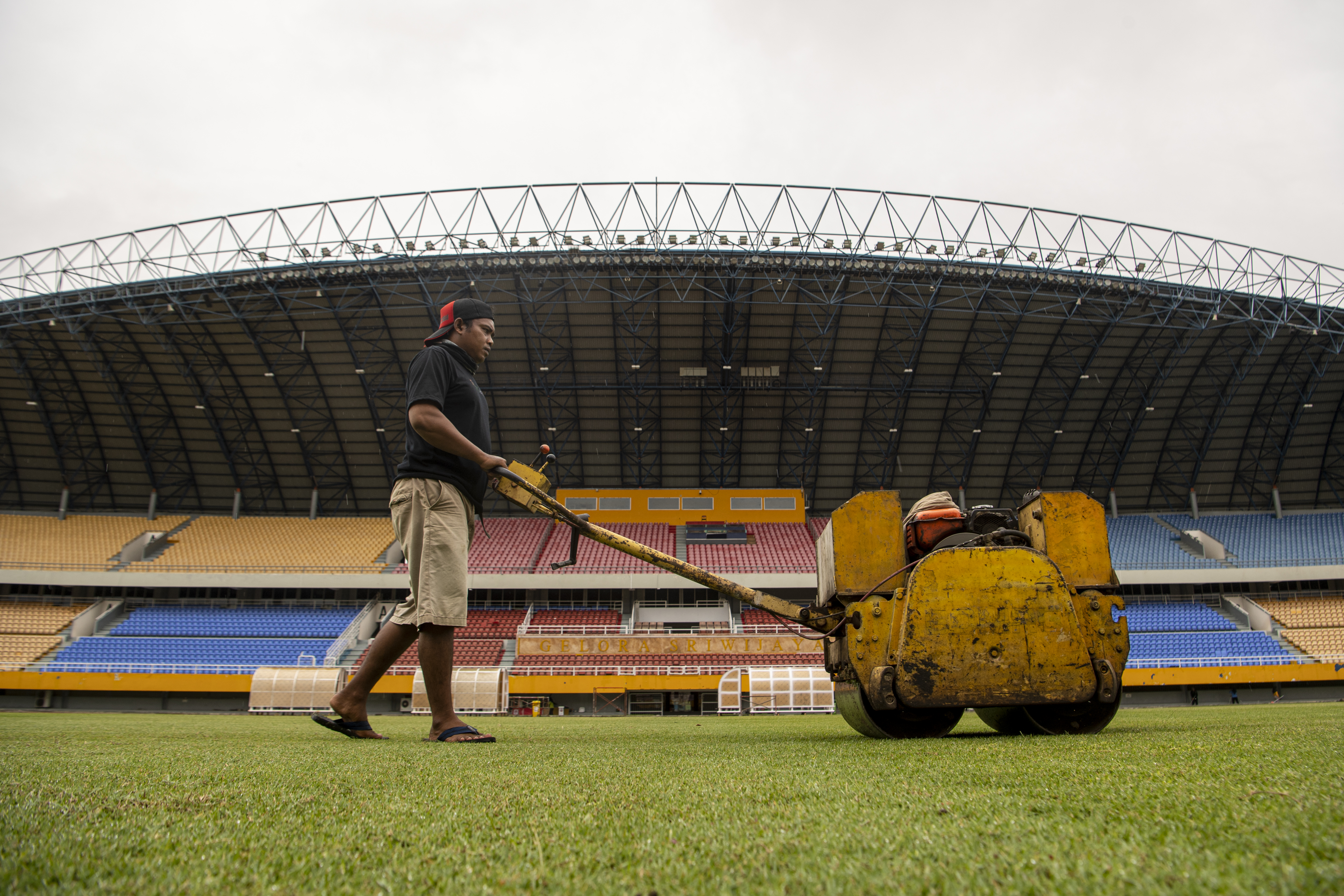 Pekerja melakukan perawatan rumput Stadion Gelora Sriwijaya Jakabaring (GSJ) sebagai persiapan Piala Dunia U20