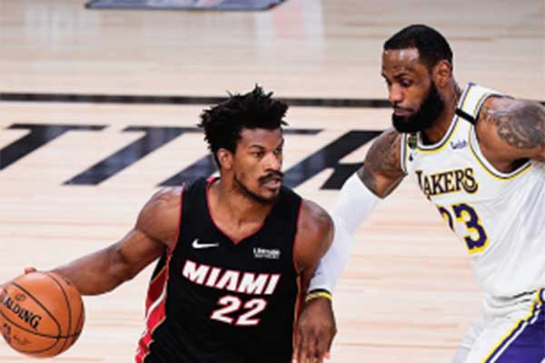 Pemain Miami Heat Jimmy Butler (kiri) dihadang bintang Los Angeles Lakers LeBron James saat membawa bola dalam gim ketiga final NBA