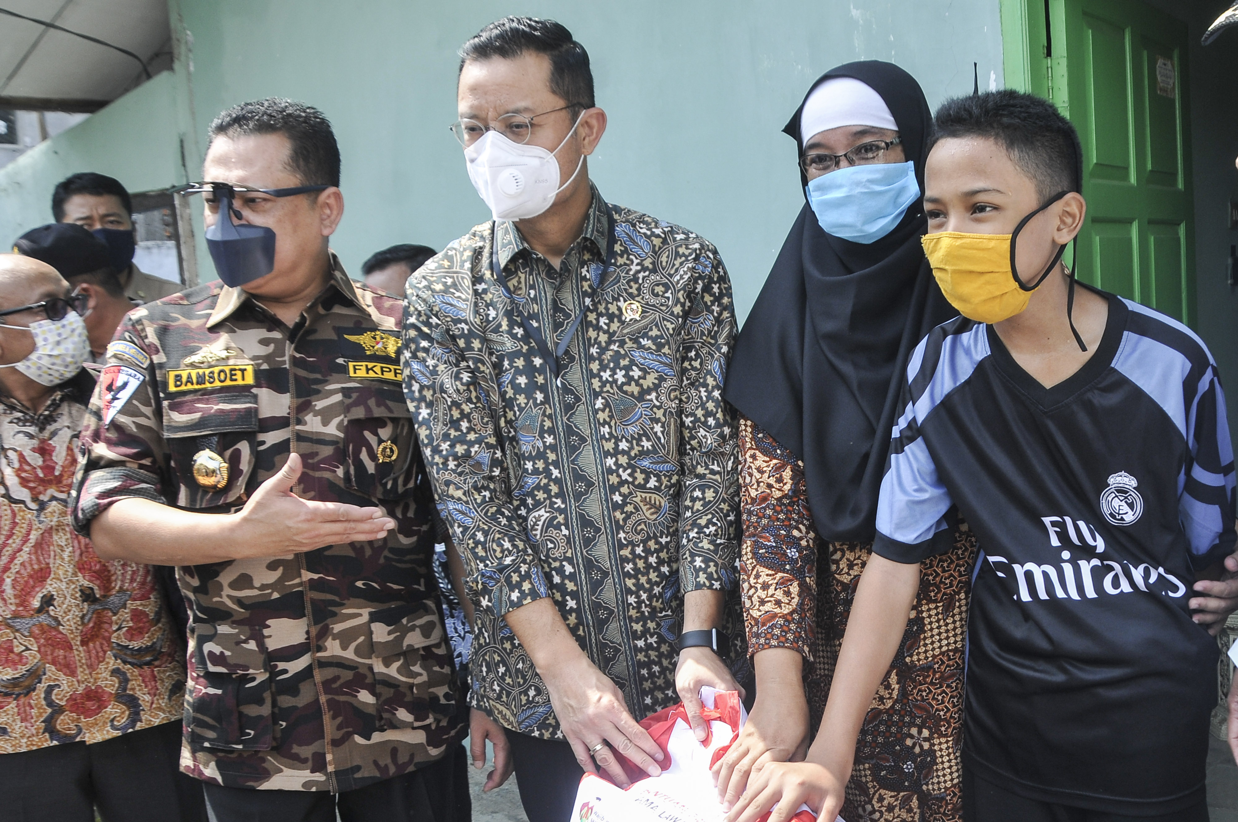 Menteri Sosial RI Juliari P Batubara (kedua kiri) bersama Wakil Ketua MPR Bambang Soesatyo (kiri) memberikan bantuan sosial.