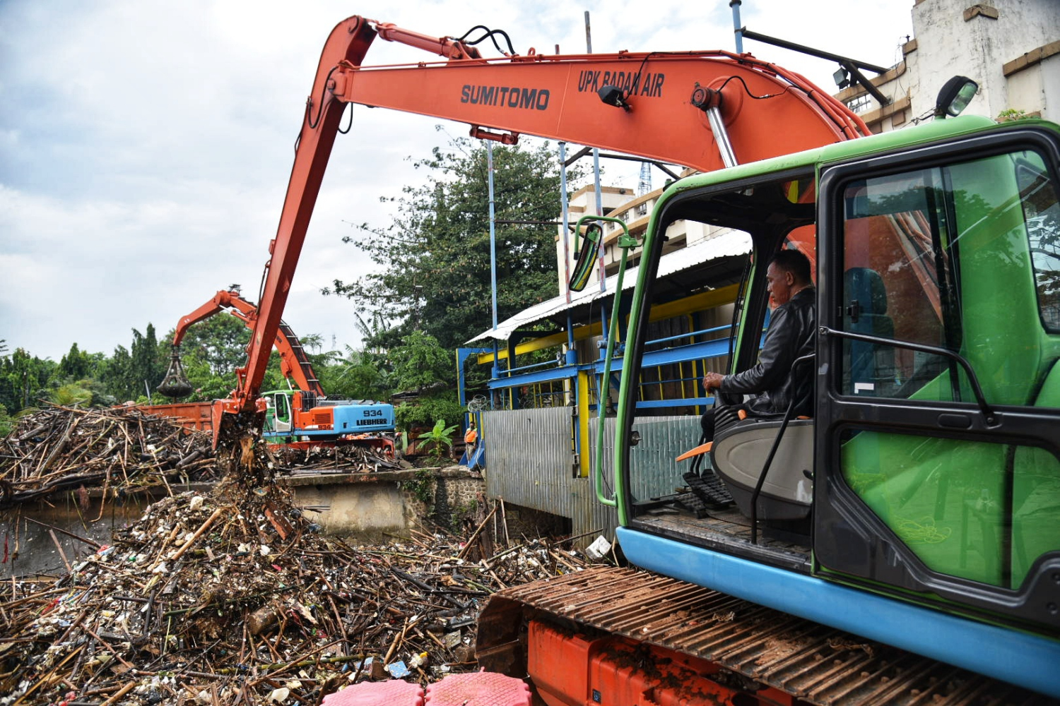 Petugas membersihkan tumpukan sampah di Pintu Air Manggarai, Jakarta.