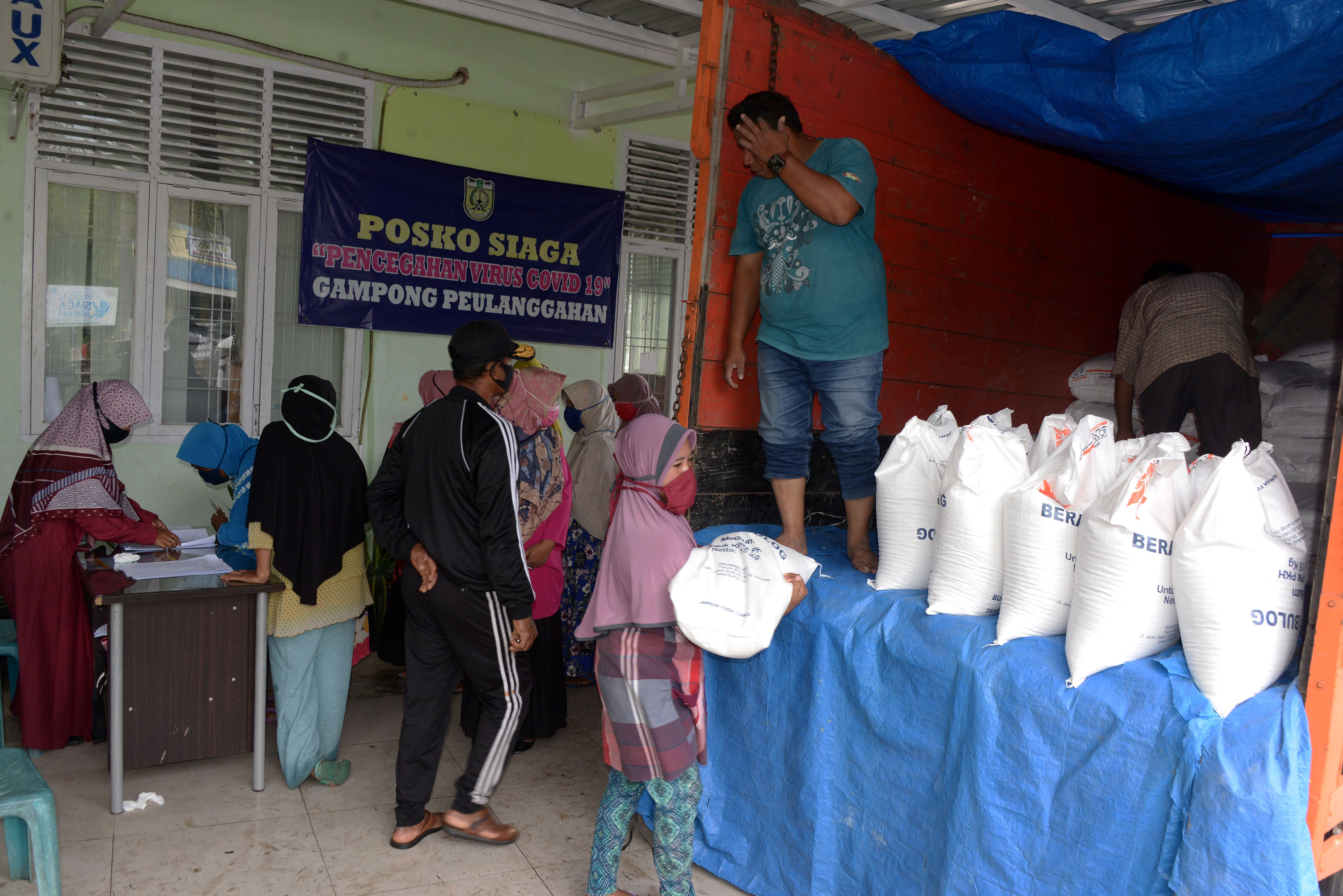 Sejumlah KPM antri memperoleh Bantuan Sosial Beras (BSB) di Desa Peulanggahan, Kecamatan Kutaraja, Banda Aceh, Aceh.