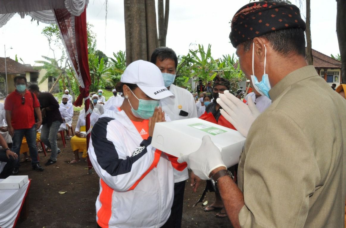 Bupati Tabanan, Bali, Ni Putu Eka Wiryastuti (kiri) menyerahkan bantuan kepada korban terdampak bencana alam.