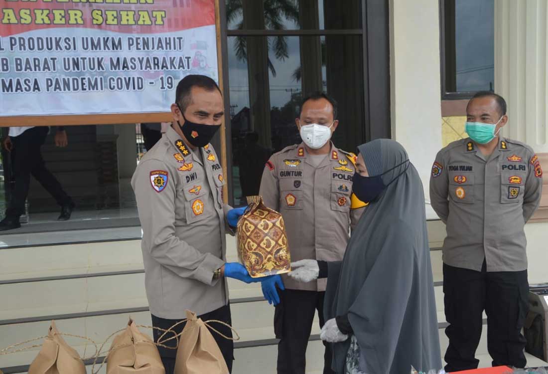 Inspektur Pengawasan Daerah Polda Jambi Komisaris Besar Dwi Gunawan menyerahkan masker kepada warga