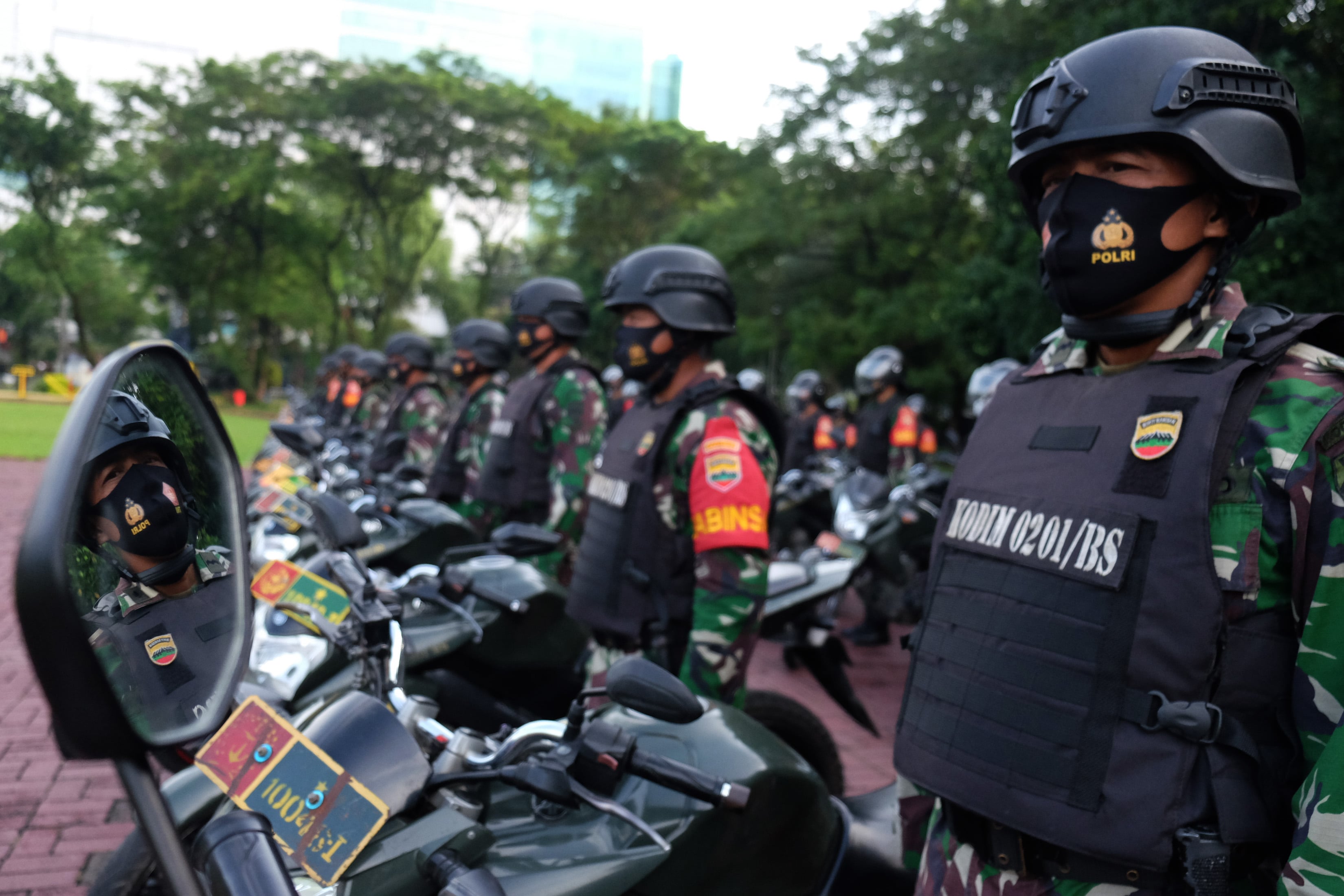 Prajurit TNI AD berada di samping sepeda motor mereka saat mengikuti Apel Gelar Pasukan TNI di Lapangan Benteng, Medan, Sumatra Utara.