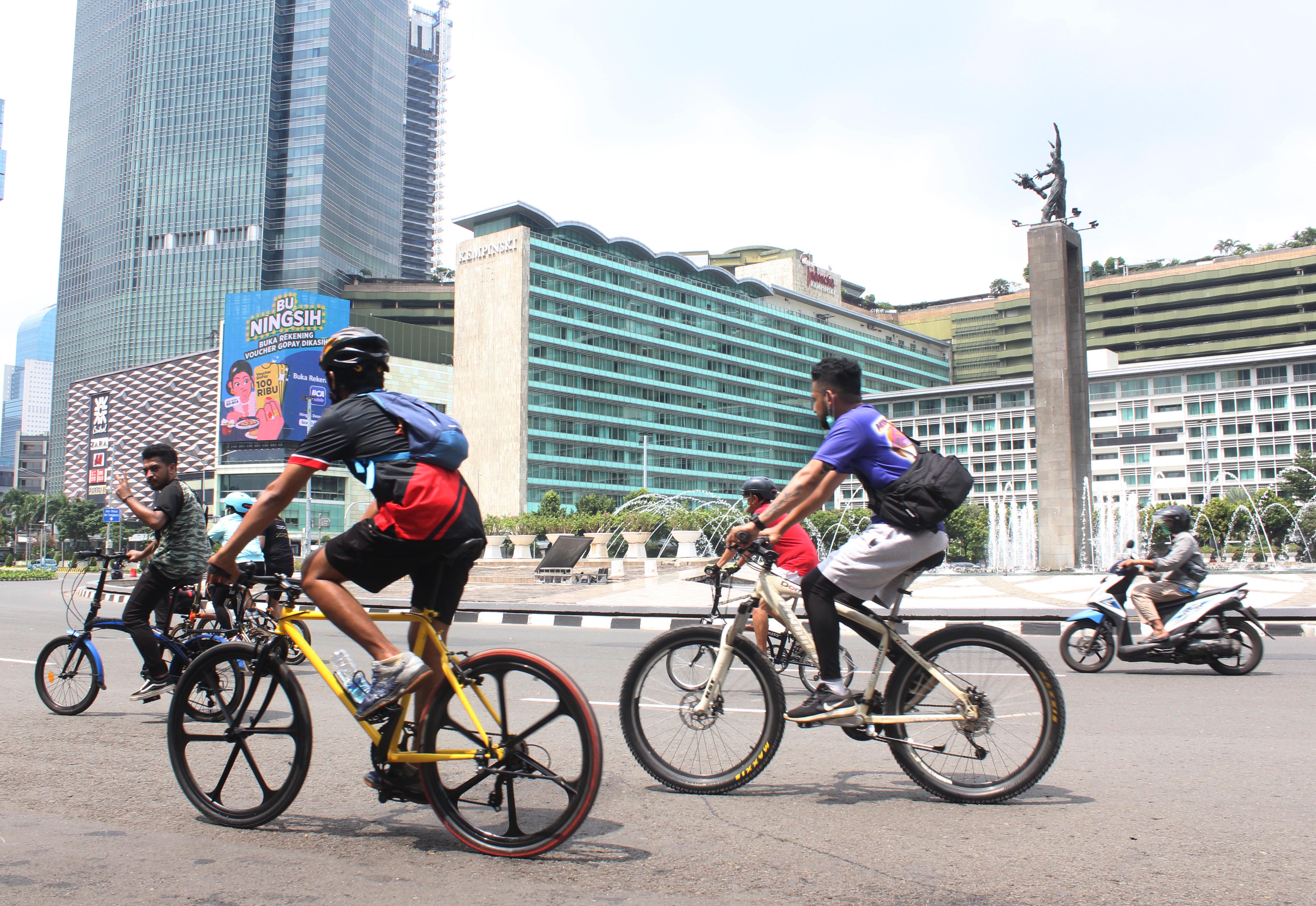 Masyarakat penguna sepeda tetap melakukan aktivitas olah raga bersepeda di Kawasan Bundaran HI, Jakarta, Minggu (25/10).