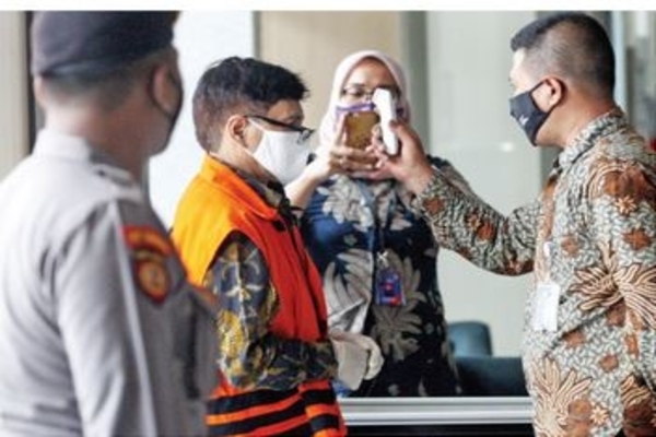Suhu tubuh terdakwa kasus Bakamla Rahardjo Pratjihno diukur saat tiba di Gedung KPK untuk menjalani sidang secara daring, Jakarta, kemarin.