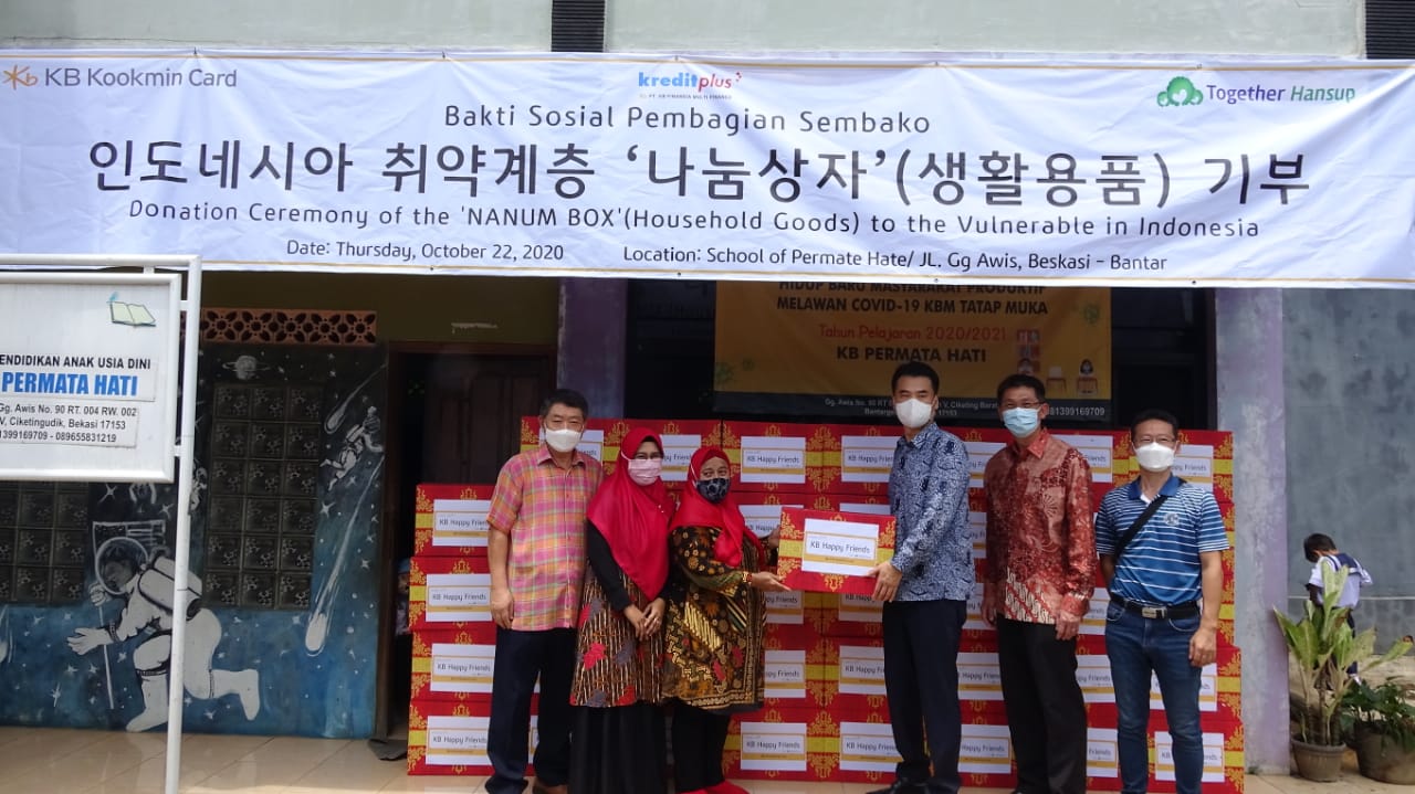 Untuk mengurangi beban masyarakat terdampak pandemi, KB Kookmin Card menyumbang kotak berisi keperluan sehari-hari dan perlengkapan sekolah.