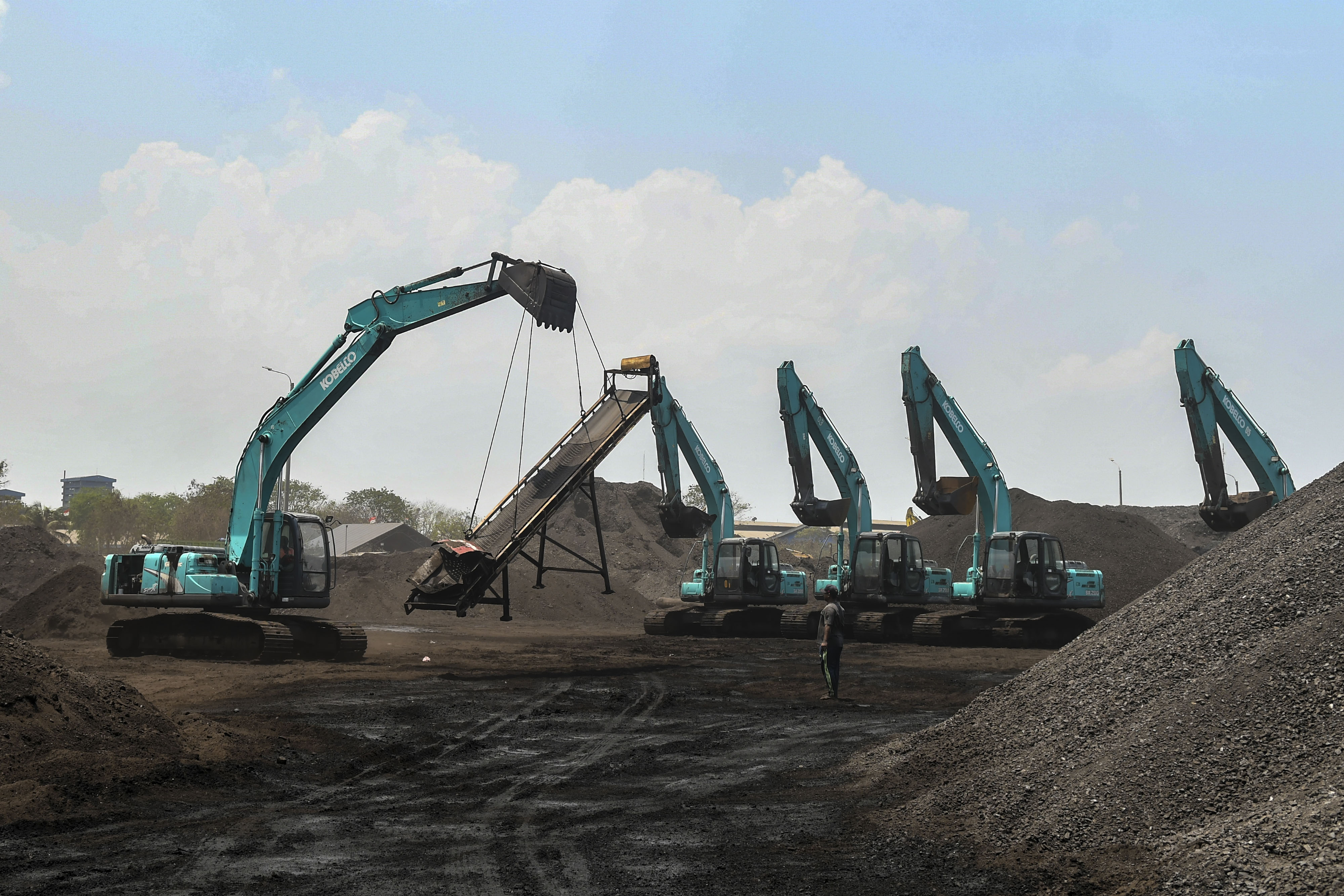 Pekerja menggunakan alat berat melakukan bongkar muat batu bara di pier 1 Pelabuhan PT Karya Citra Nusantara, Marunda, Jakarta Utara, 2019.