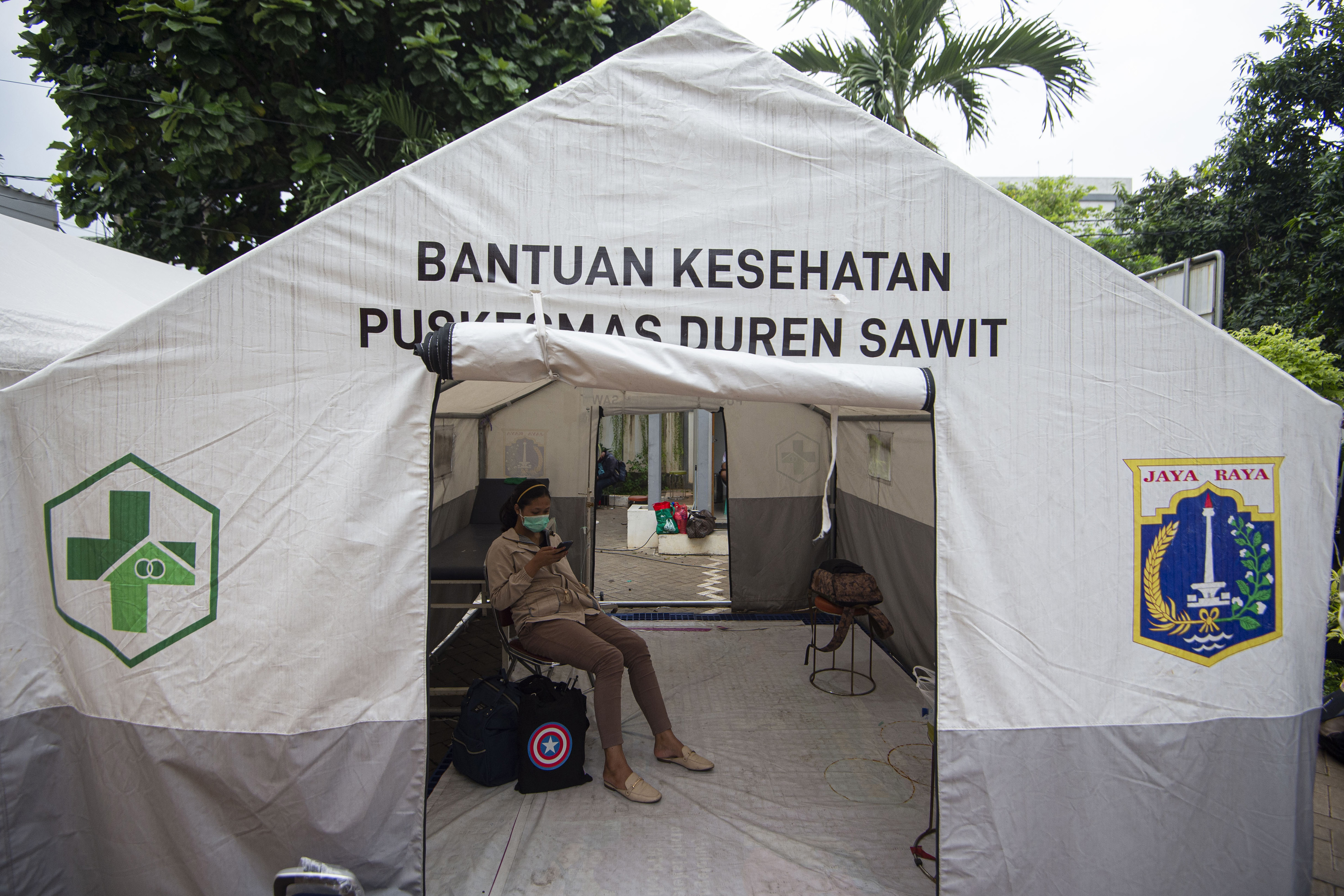 Pasien COVID-19 menunggu penjemputan dirinya ke Rumah Sakit Darurat Penanganan COVID-19 Wisma Atlet Kemayoran di Puskesmas Duren Sawit.