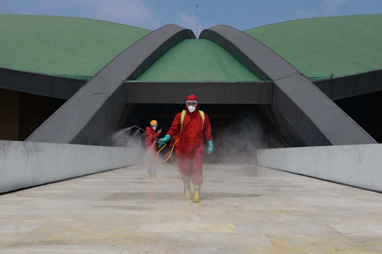 Petugas Pemadam Kebakaran Kota Jakarta menyemprotkan cairan disinfektan di Kompleks Parlemen DPR MPR RI, Senayan, Jakarta, Minggu (9/8/2020)