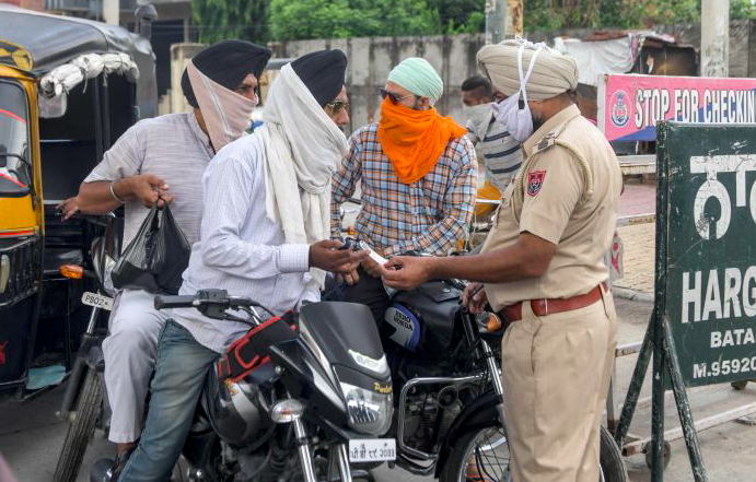 Ilustrasi - Polisi memeriksa kelengkapan surat-surat pengendara motor di Amritsar, India.  