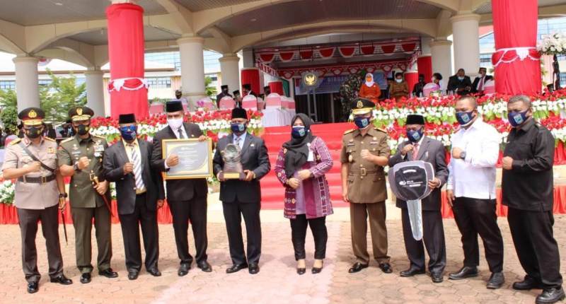 Gubernur Papua Barat Dominggus Mandacan dan Kepala BP Jamsostek Papua Barat Mince Wattu saat menerima gelar juara III Paritrana Award.