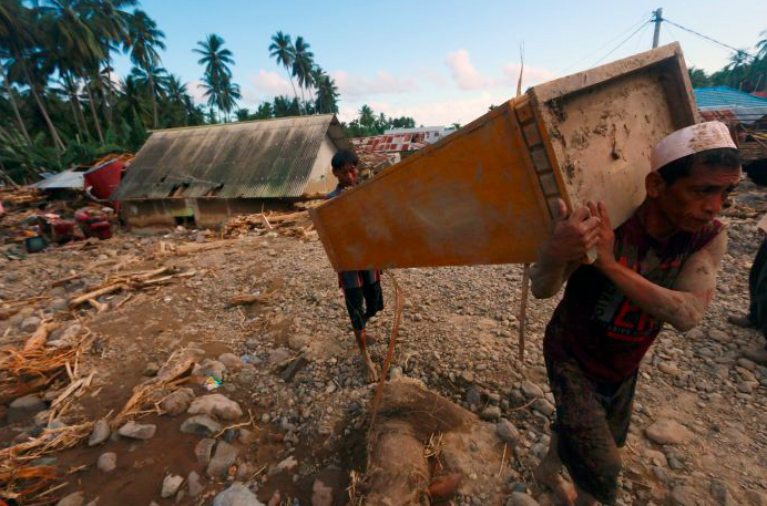 Warga korban banjir menyelamatkan sisa perabot yang terdampak banjir bandang di Gorontalo.  