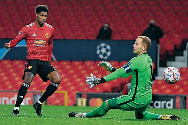 Striker Manchester United Marcus Rashford mencetak gol kedua timnya melewati kiper RB Leipzig Peter Gulacsi 