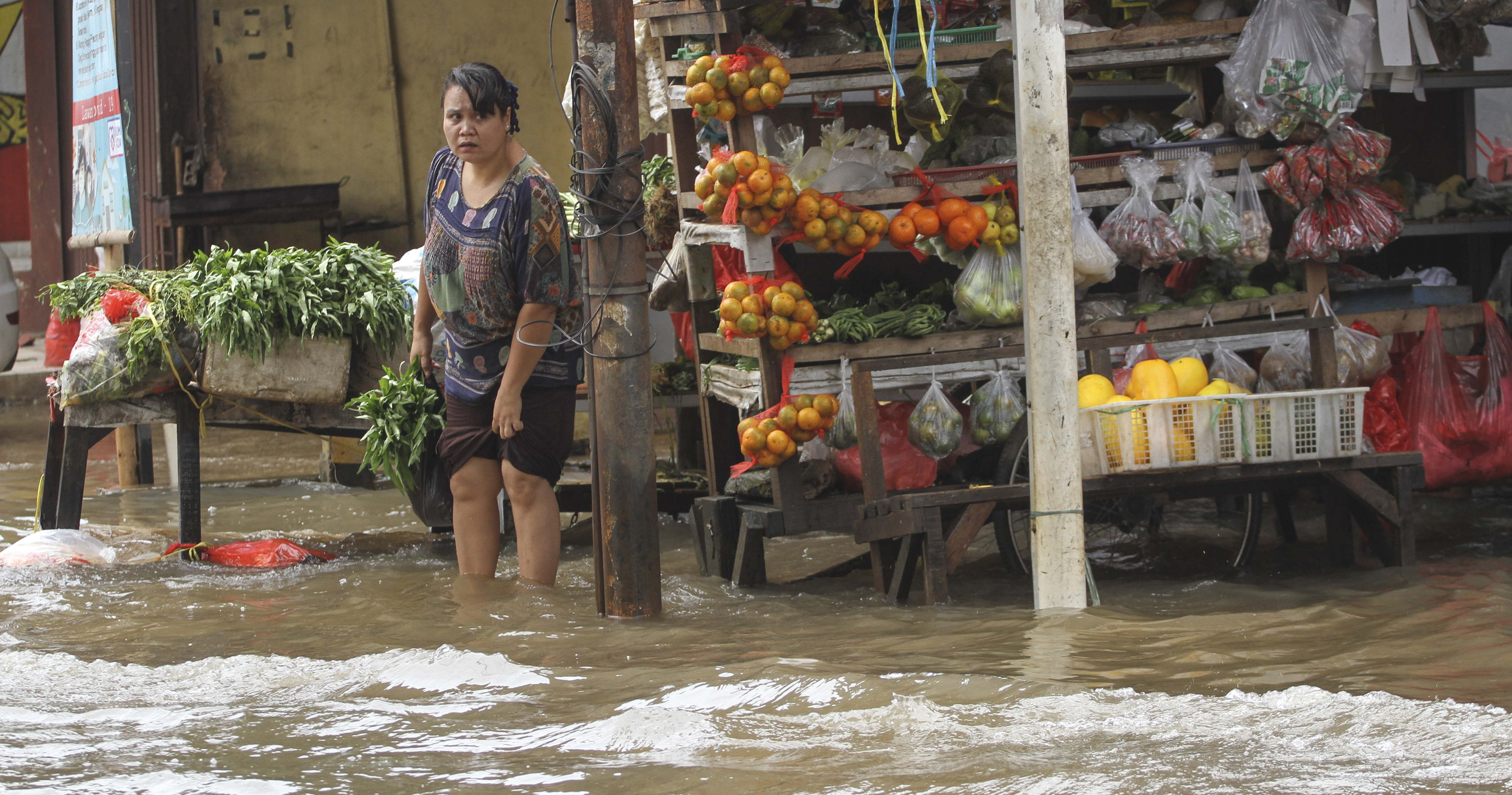 Dokumentasi: Seorang warga berbelanja saat terjadi genangan air di Mampang, Depok, Jawa Barat, Jumat (24/4/2020). 