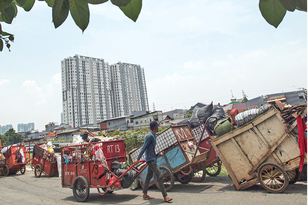 UPAYA MENGURANGI SAMPAH DI IBU KOTA Petugas menarik gerobak sampah di Sunter Agung, Tanjung Priok, Jakarta Utara, kemarin