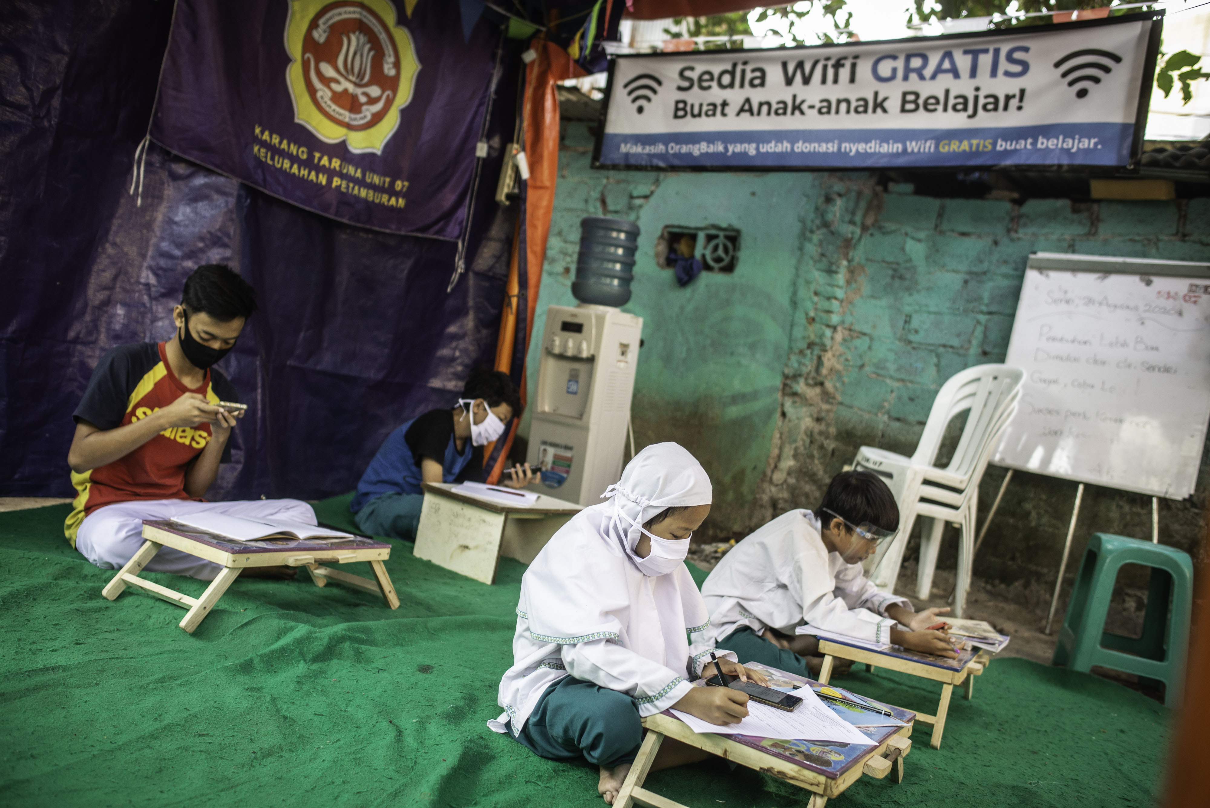 Sejumlah pelajar belajar jarak jauh  dengan memanfaatkan jaringan internet hasil swadaya warga Petamburan, Jakarta 
