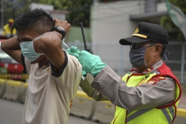 Ilustrasi -- Polisi memberikan masker kepada pengendara sepeda motor saat penerapan PSBB di kawasan Menteng, Jakarta, Sabtu, 11 April 2020. 
