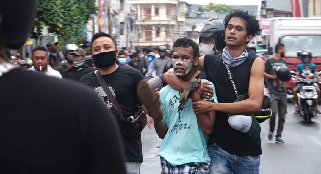Polisi menangkap seorang demonstran saat aksi demonstrasi menolak UU Cipta Kerja di Ternate, Maluku Utara.
