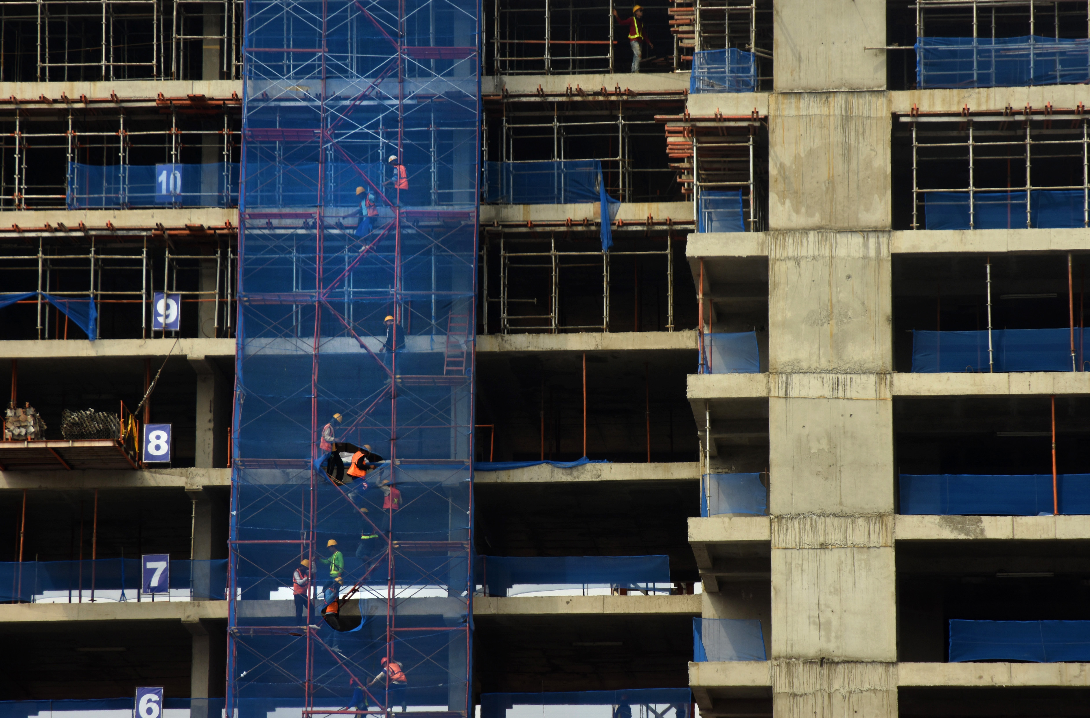 Ilustrasi pekerja menyelesaikan pembangunan proyek apartemen.