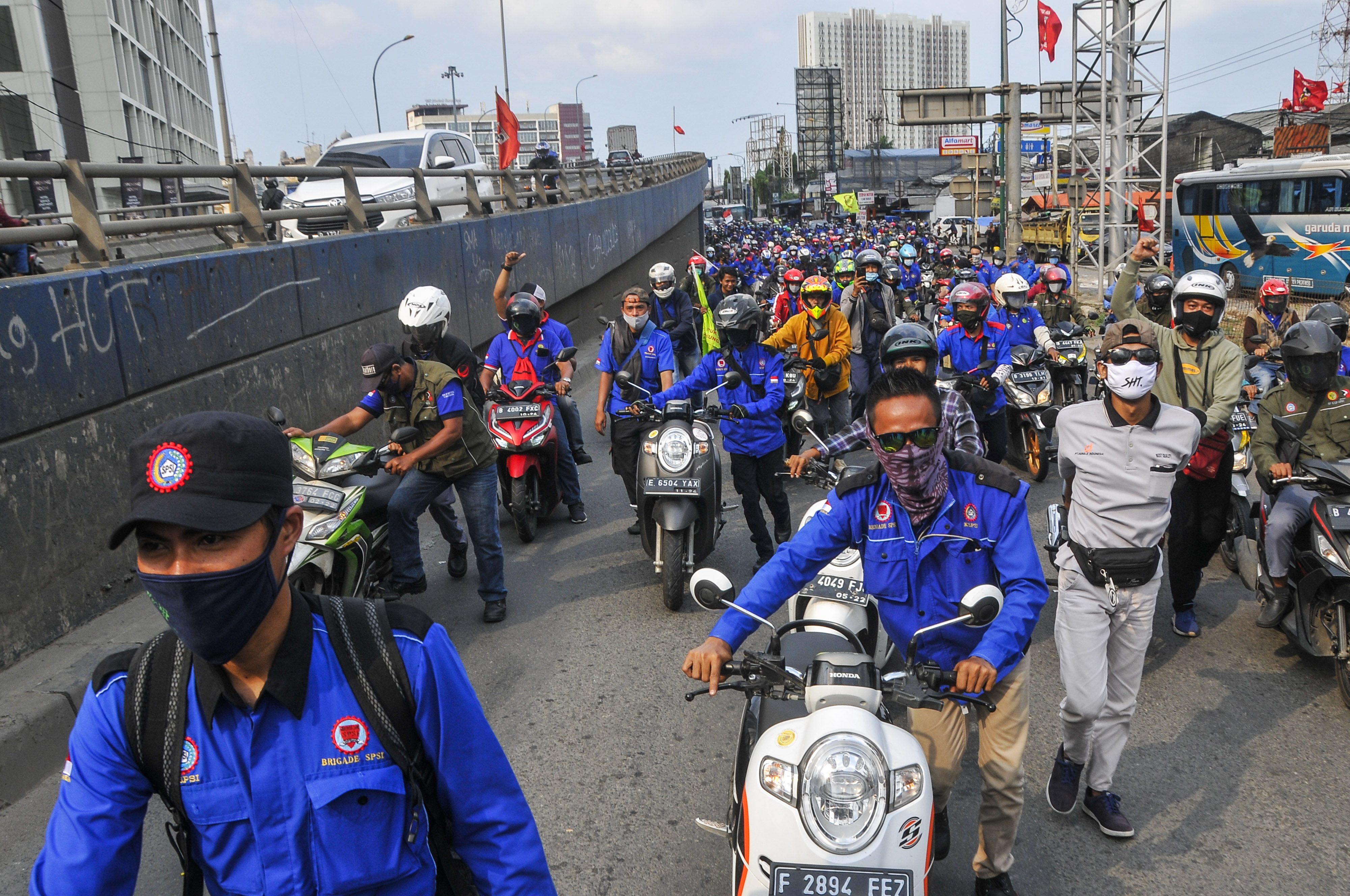 Aksi buruh di Cikarang menolak UU CIpta Kerja dengan mendorong sepeda motor