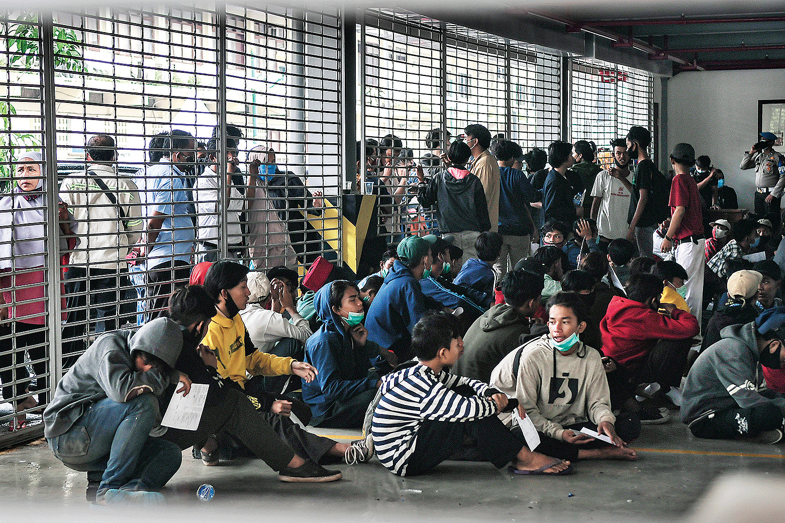 PENGUNJUK RASA ANARKISTIS DIAMANKAN:Puluhan pengunjuk rasa menolak UU Cipta Kerja dikumpulkan di Gedung Parkir Barang Bukti Ranmor di Polda