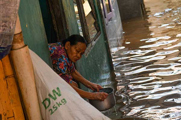 Warga membersihkan rumahnya yang terendam banjir 
