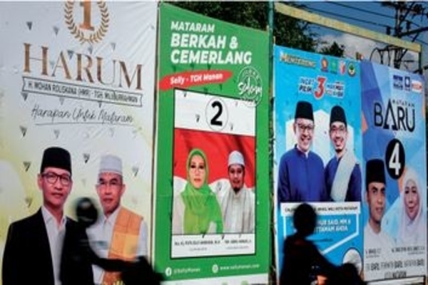 Ilustrasi -- Pengendara motor melintas di depan baliho kampanye peserta pilkada serentak Kota Mataram, NTB, kemarin.