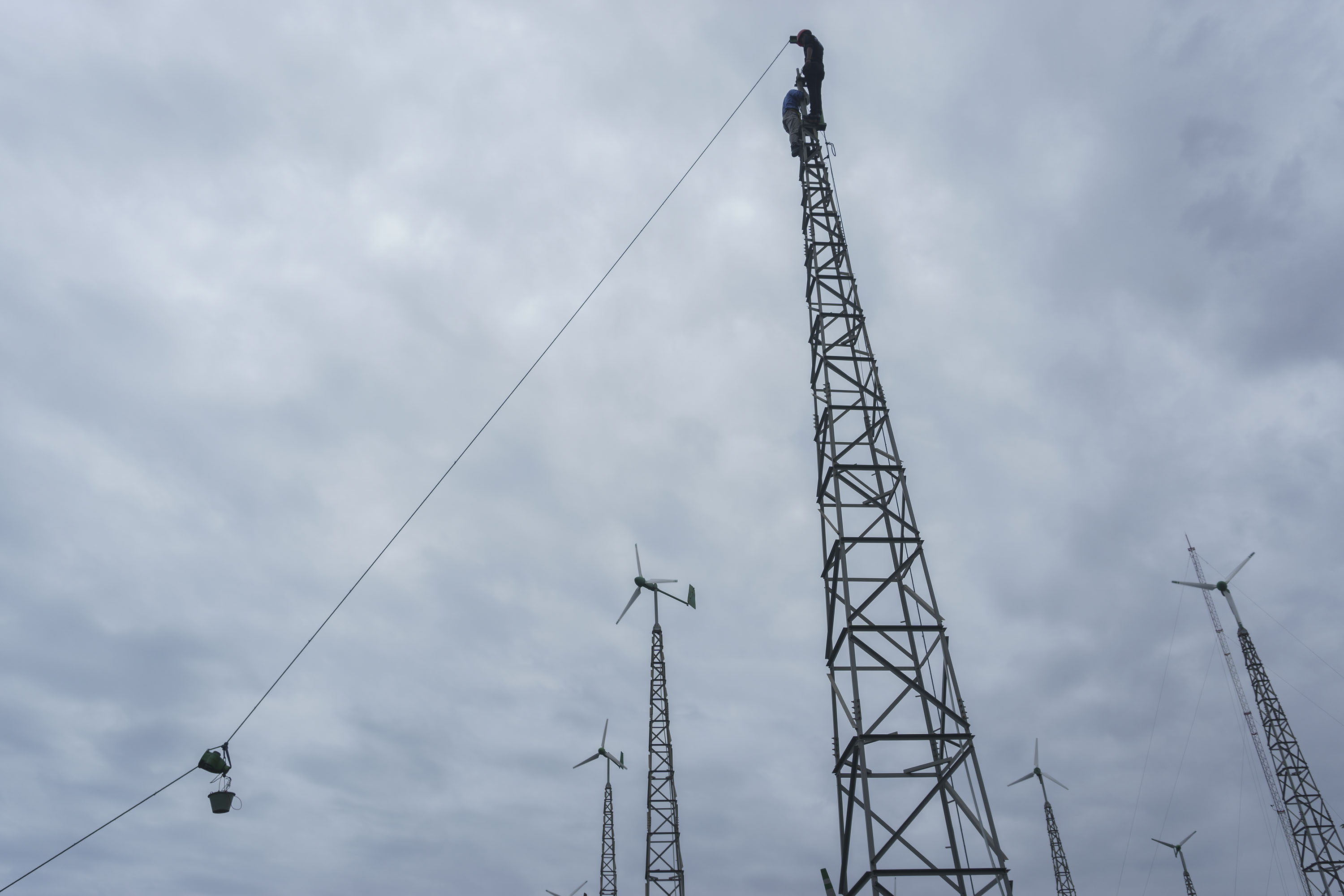 Pekerja melakukan proses perbaikan kincir angin di Pembangkit Listrik Tenaga Hibrid (PLTH),