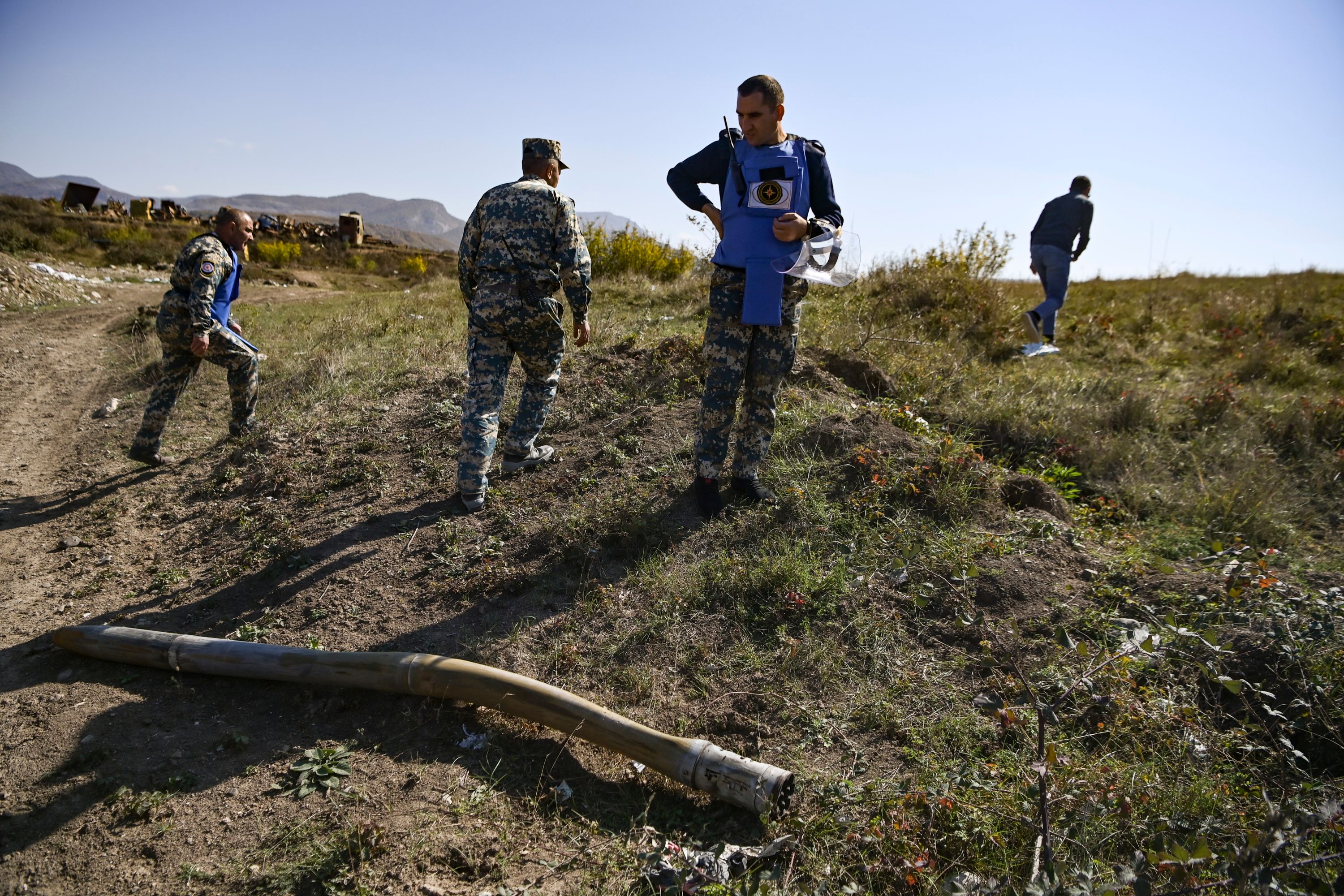 Personel Kementerian Situasi Darurat Karabakh melihat roket yang tidak meledak di Stepanakert seiring konflik antara Azerbaijan dan Armenia.