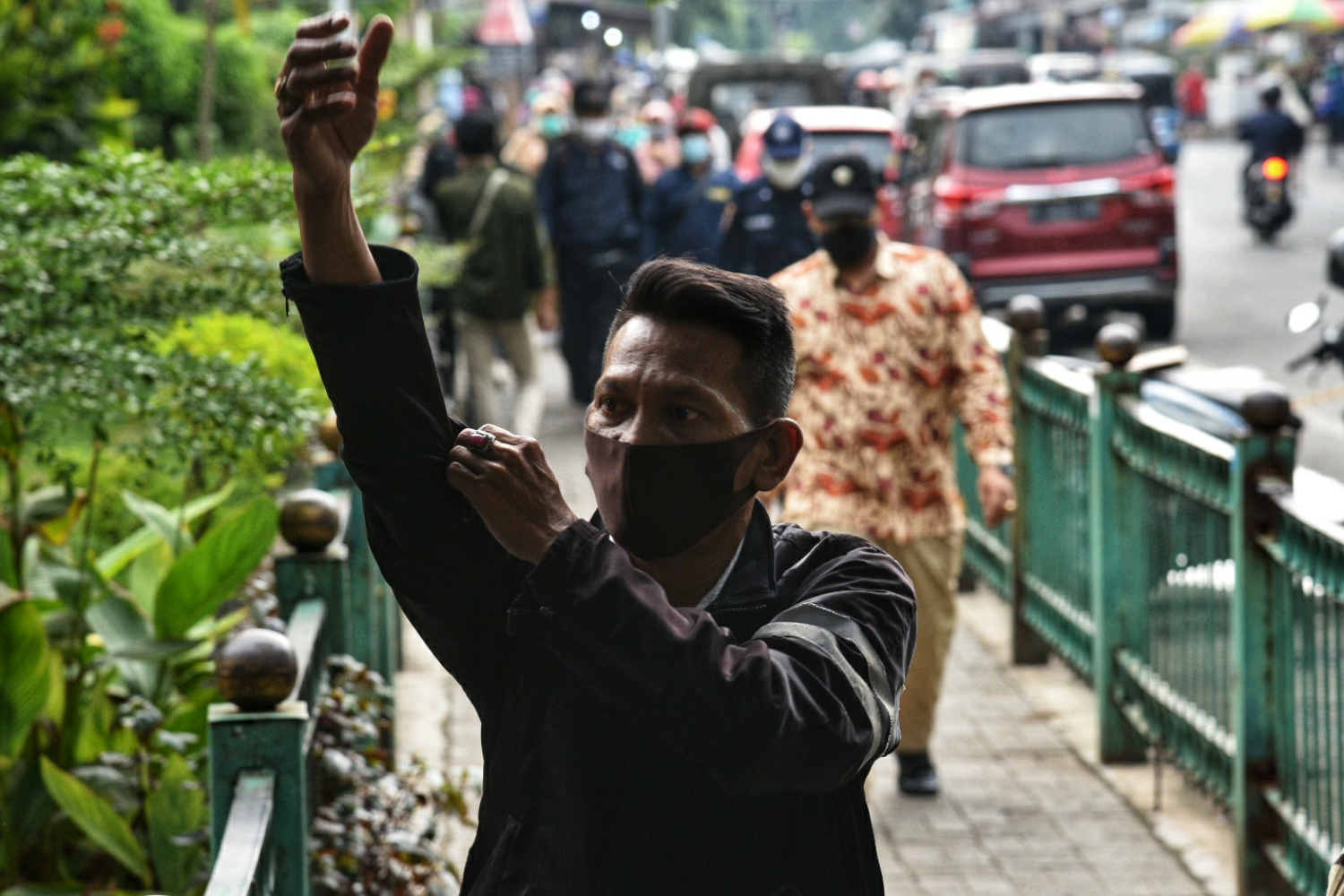 Calon penumpang kereta Commuter Line memakai masker scuba berjalan di kawasan Stasiun Manggarai, Jakarta.
