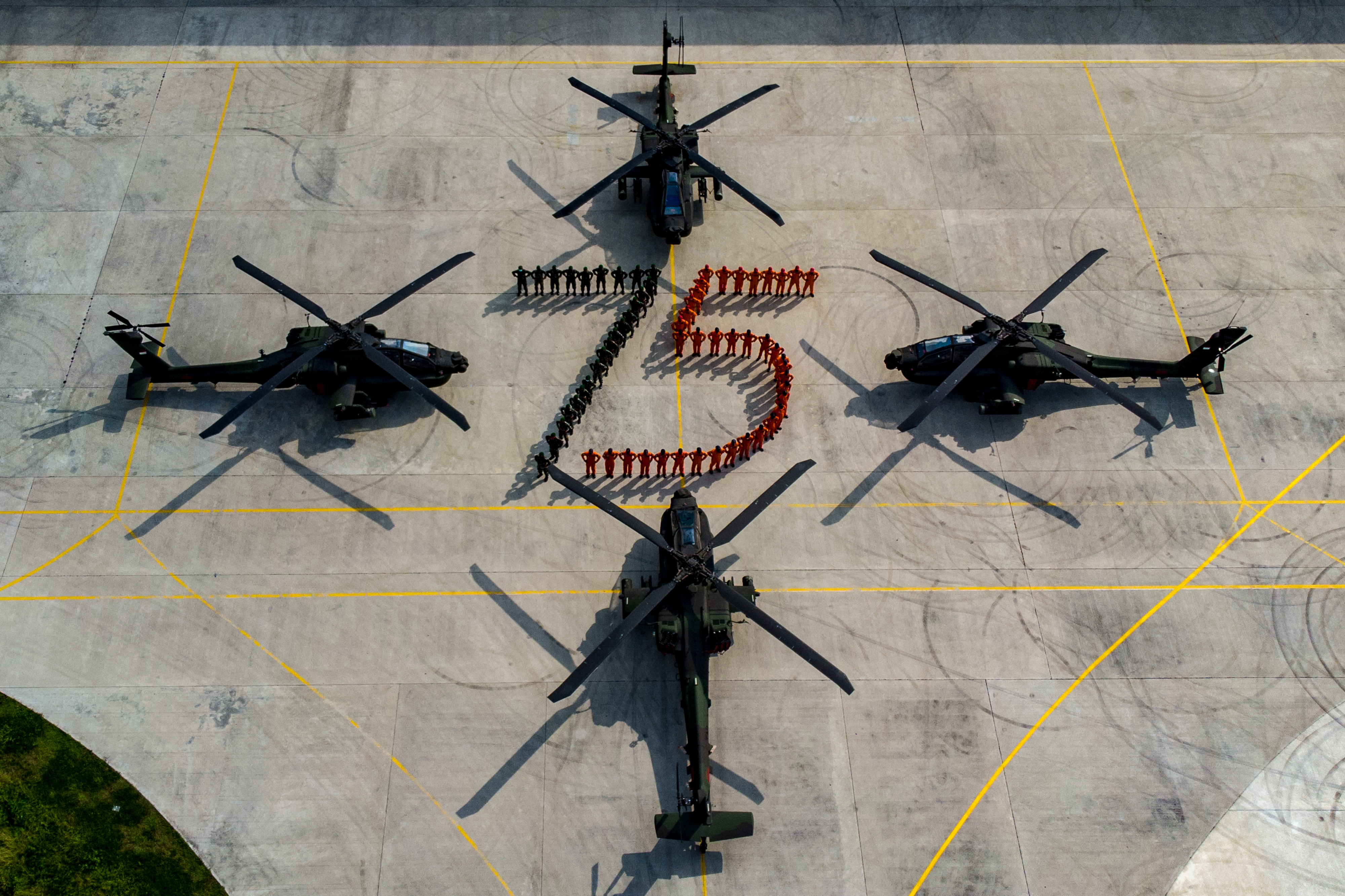 Prajurit TNI-AD dari Skadron-11/Serbu Puspenerbad membentuk formasi angka 75 dikelilingi sejumlah helikopter AH-64E Apache.
