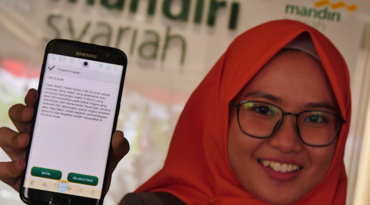  Pegawai Mandiri Syariah tengah menunjukkan fi tur wakaf sukuk CWLS Aceh diMandiri Syariah Mobile, di Aceh