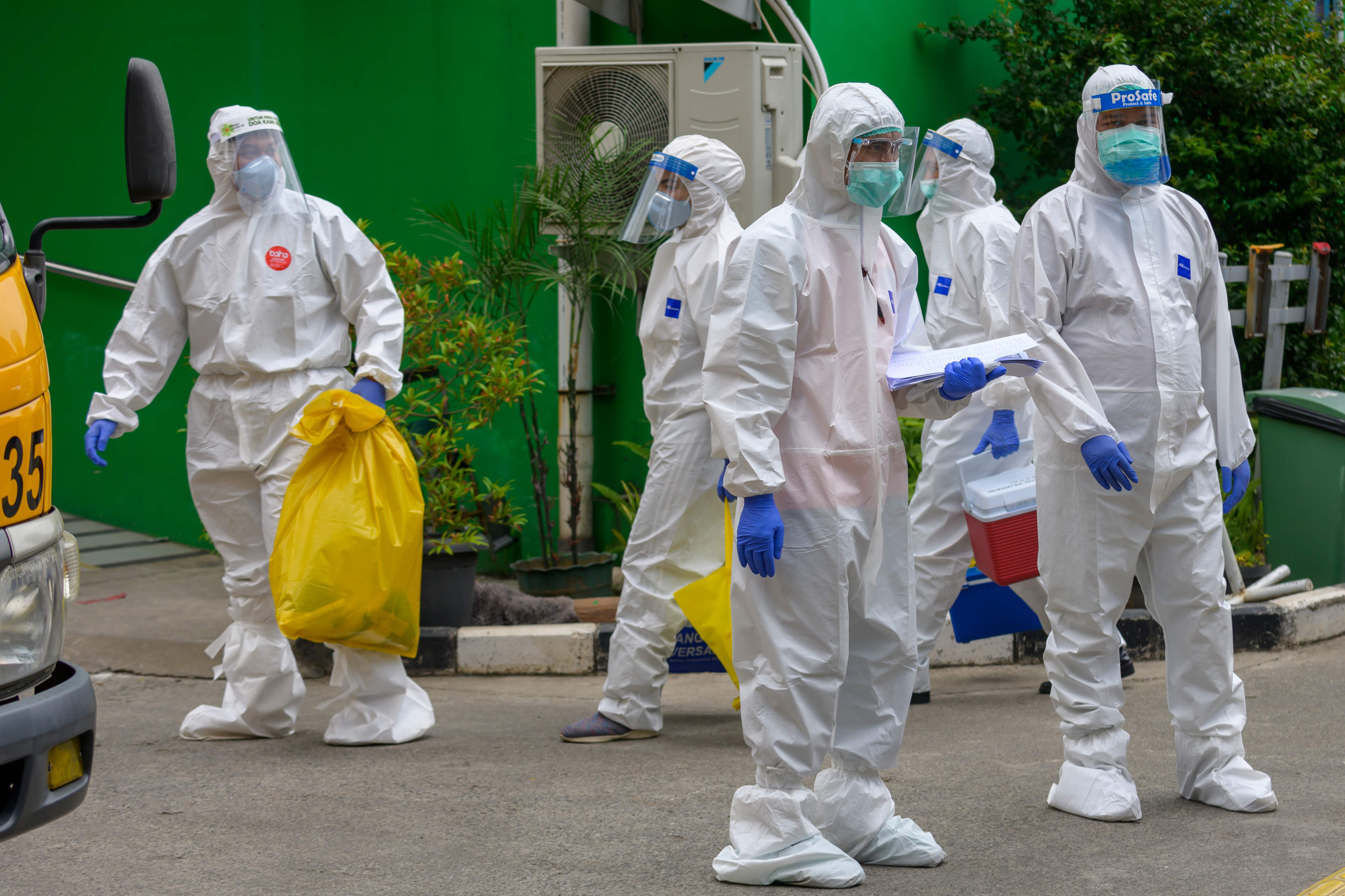 Petugas berpakaian APD lengkap bersiap menjemput pasien covid-19 di Jakarta.
