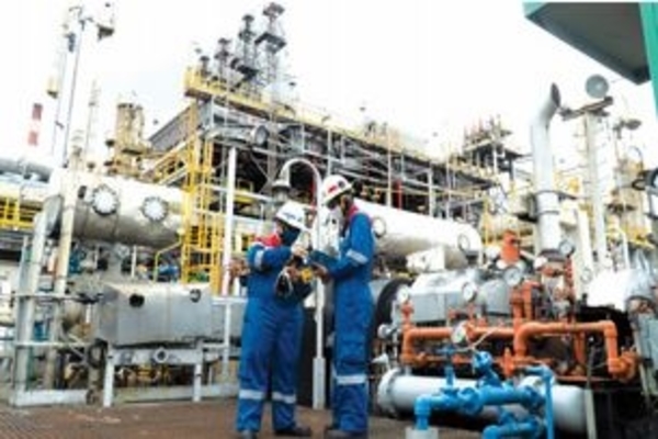 Dua pekerja sedang beraktivitas di Kilang Dumai Pertamina, menghasilkan bahan bakar D 100% green diesel yang diolah dari minyak sawit