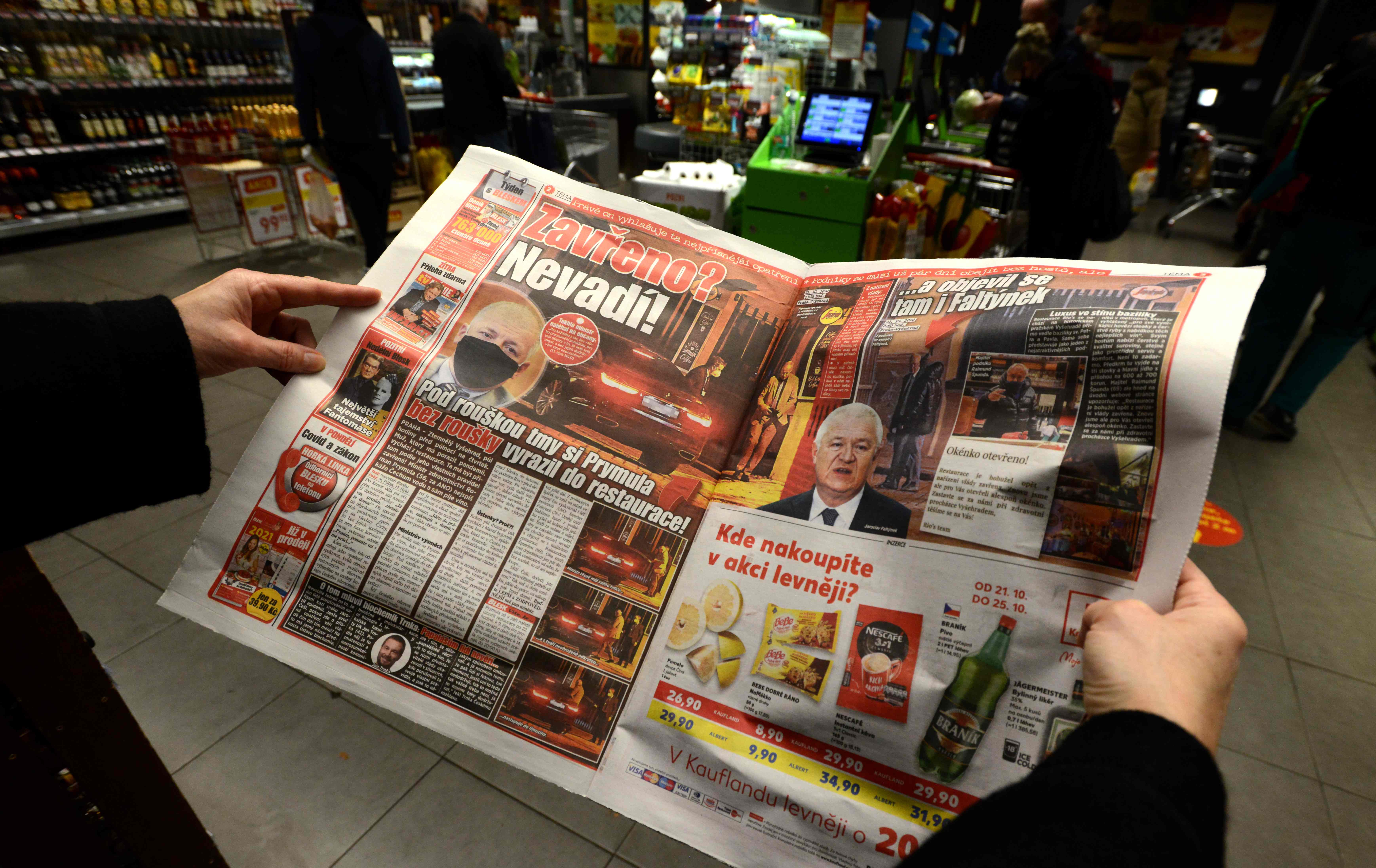 Seorang warga memegang surat kabar Rep Ceko yang melaporkan soal pelanggaran protokol kesehatan yang dilakukan Menkes Roman Prymula.