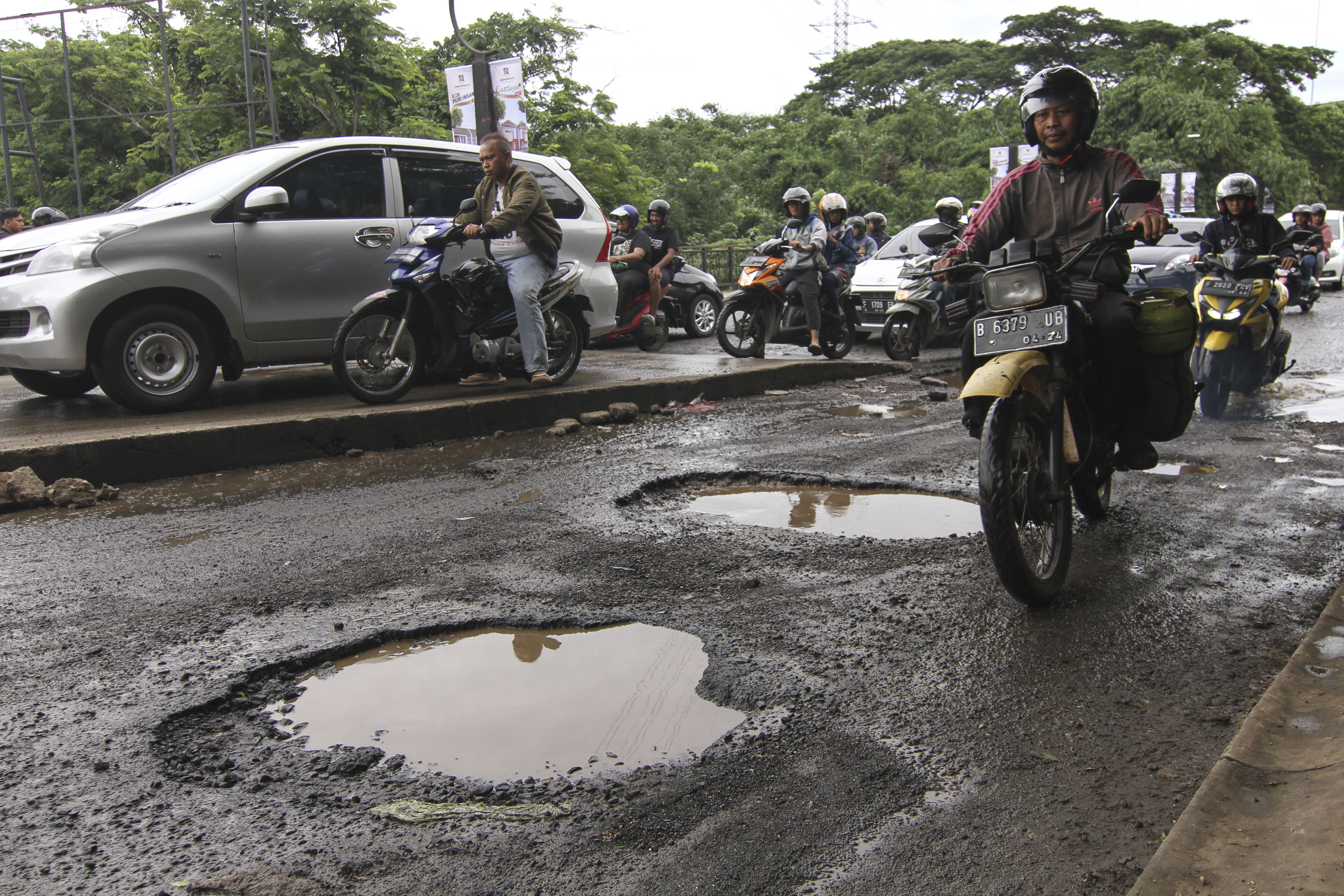  Sejumlah pengendara melintasi jalan yang rusak di GDC, Depok, Jawa Barat, Sabtu (11/1/2020
