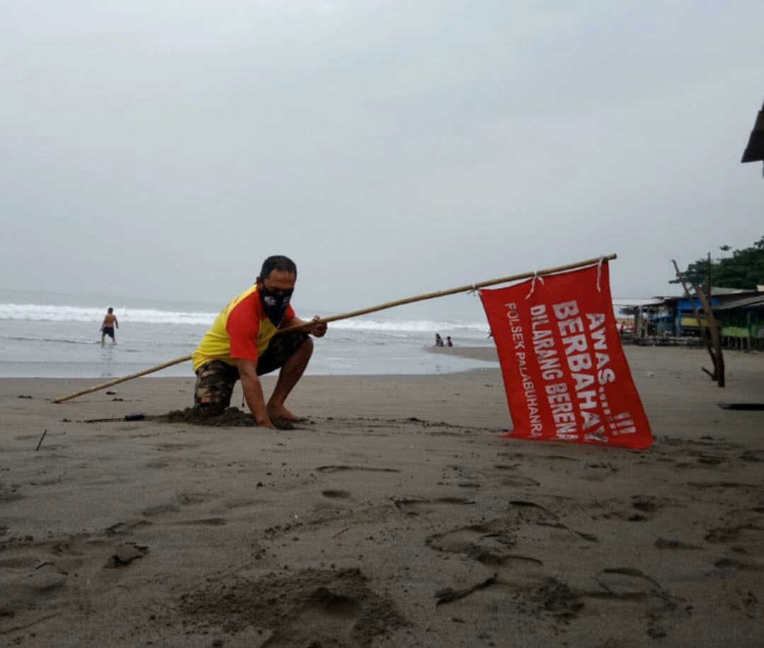 Kepala Operasional dan SDM Balawista Kabupaten Sukabumi, Jawa Barat, Asep Edom Saepulloh, memasang rambu larangan berenang.