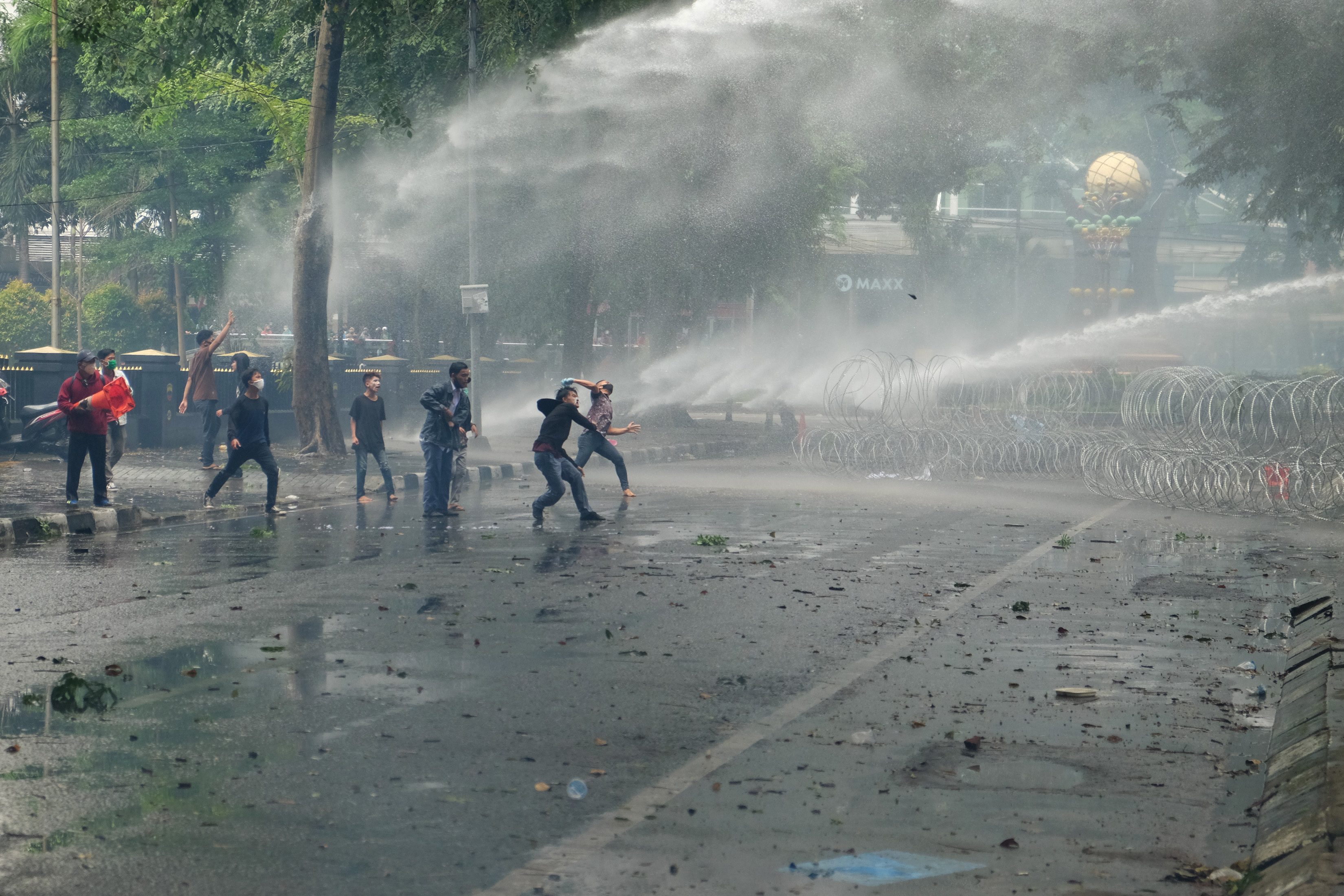 Pengunjuk rasa melempar batu ke arah gedung DPRD Sumatera Utara saat demo menolak UU Cipta Kerja di Medan, Kamis (8/10).
