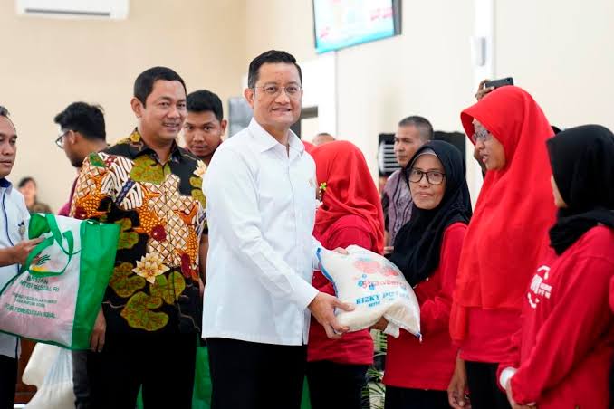 Menteri Sosial Juliari P Batubara (ketiga dari kiri) tengah memberikan paket bantuan kepada warga.
