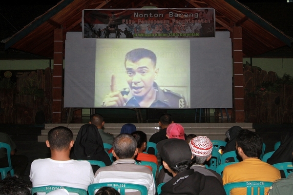 Ilustrasi -- Sejumlah warga menonton film penumpasan pengkhianatan G30S/PKI di markas Kodim 1304 Gorontalo. 
