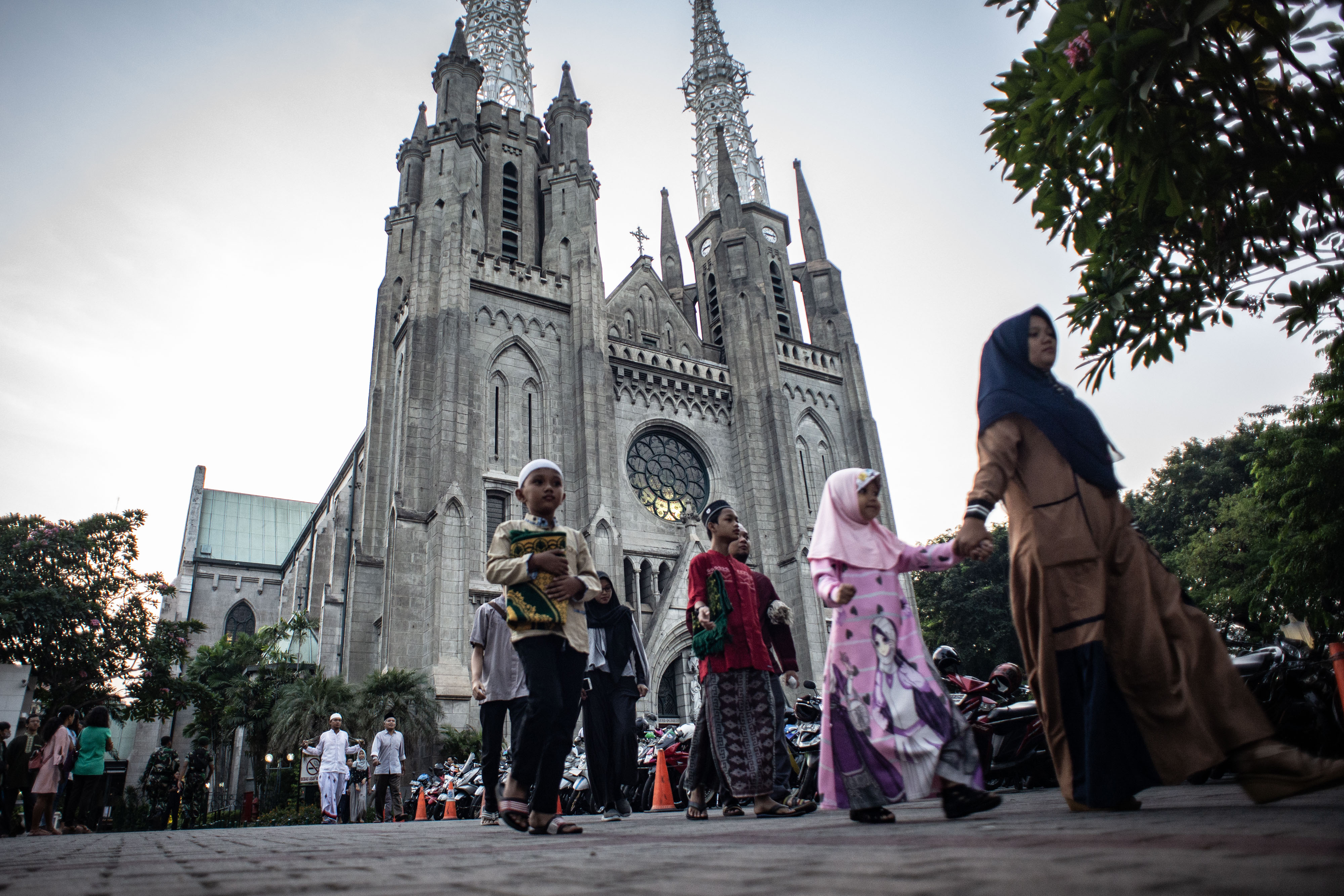 Sejumlah umat Muslim menuju Masjid Istiqlal seusai memarkir kendaraan di halaman Gereja Katedral.
