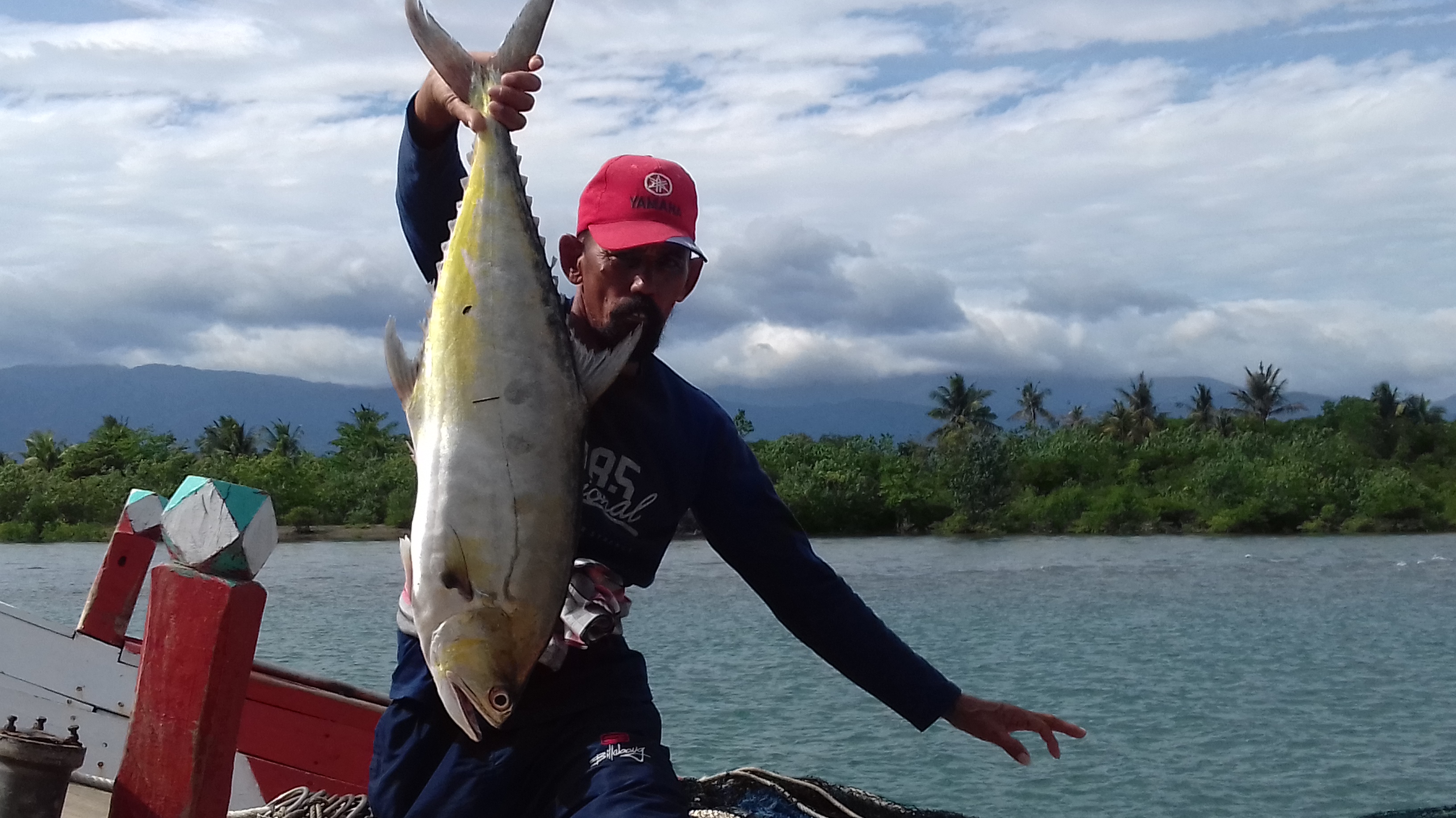 Seorang nelayan memperlihatkan ikan hasil tangkapannya di Aceh.