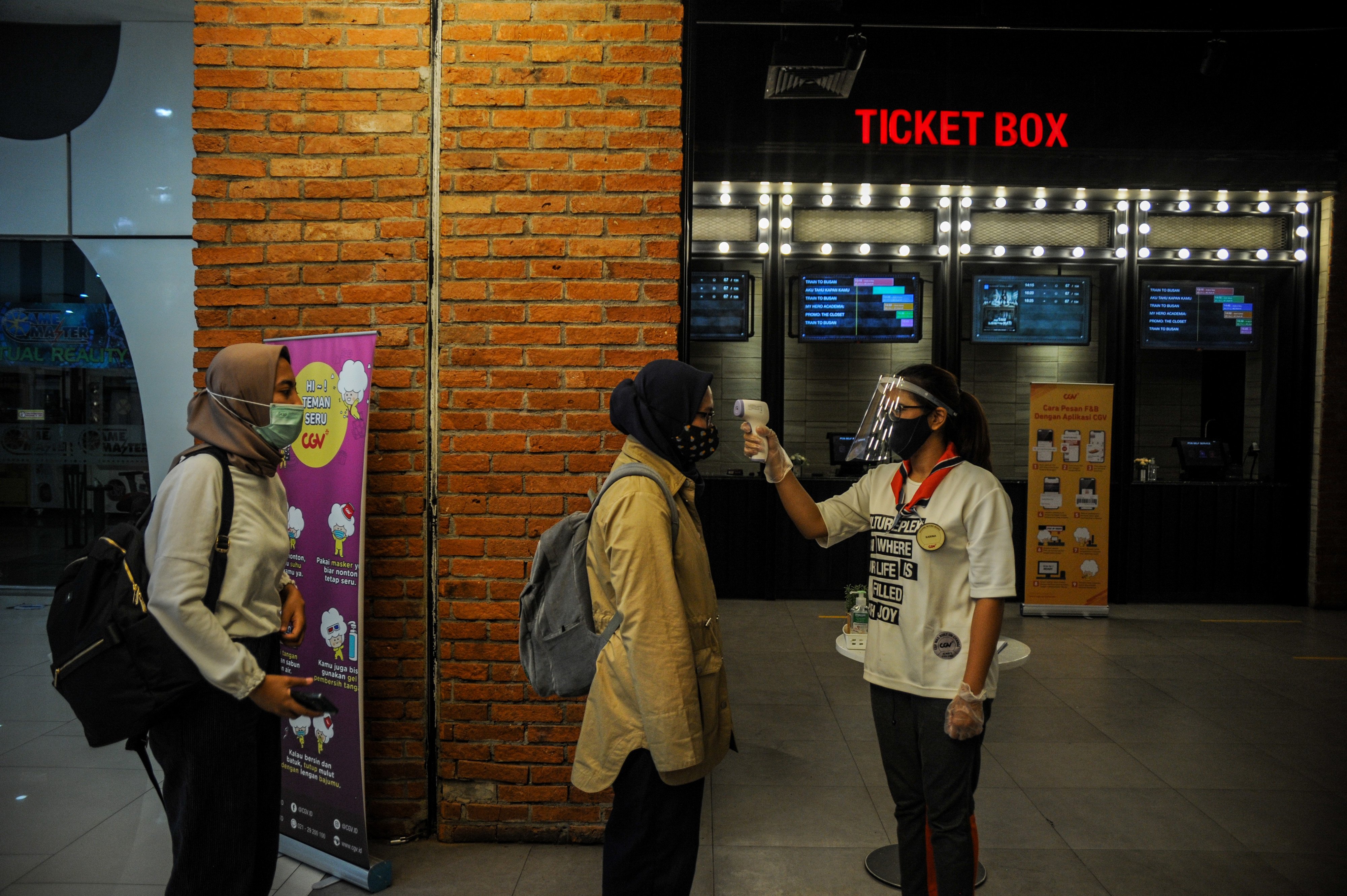 Ilustrasi: Petugas memeriksa suhu tubuh pengunjung yang akan menonton film di salah satu bioskop di Kota Bandung