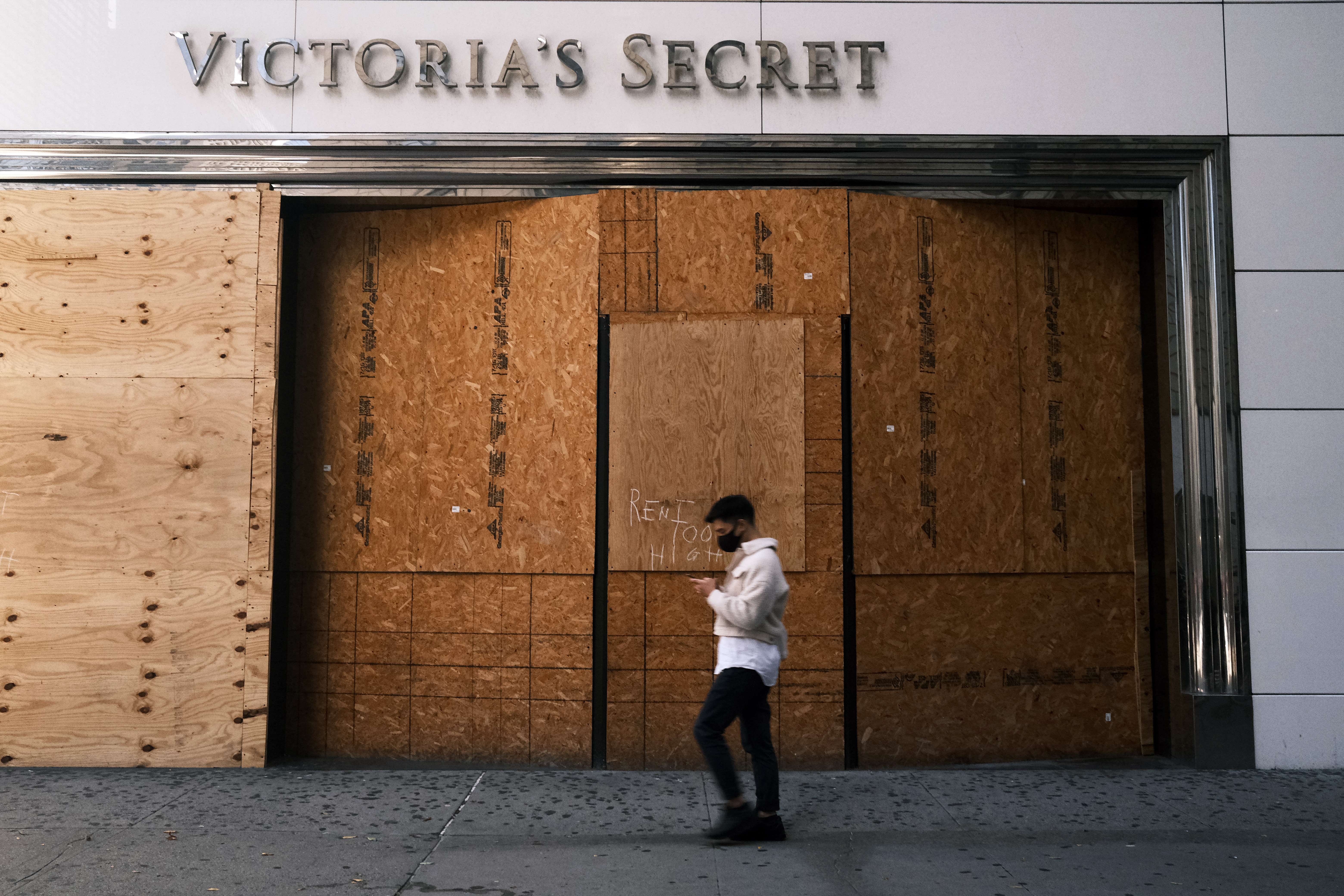 Seorang pejalan kaki berjalan di depan toko yang tutup akibat pandemi covid-19 di AS