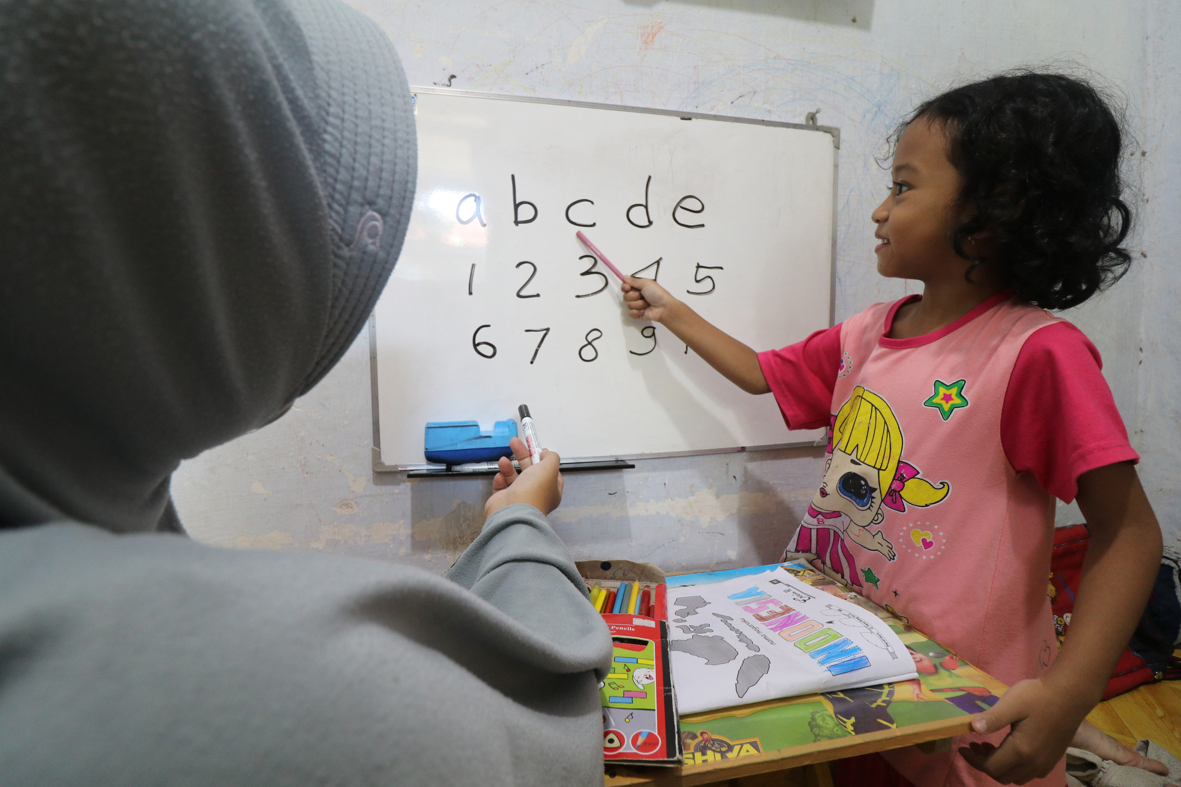 Seorang ibu mendampingi anaknya belajar daring di rumah selama pandemi covid-19.