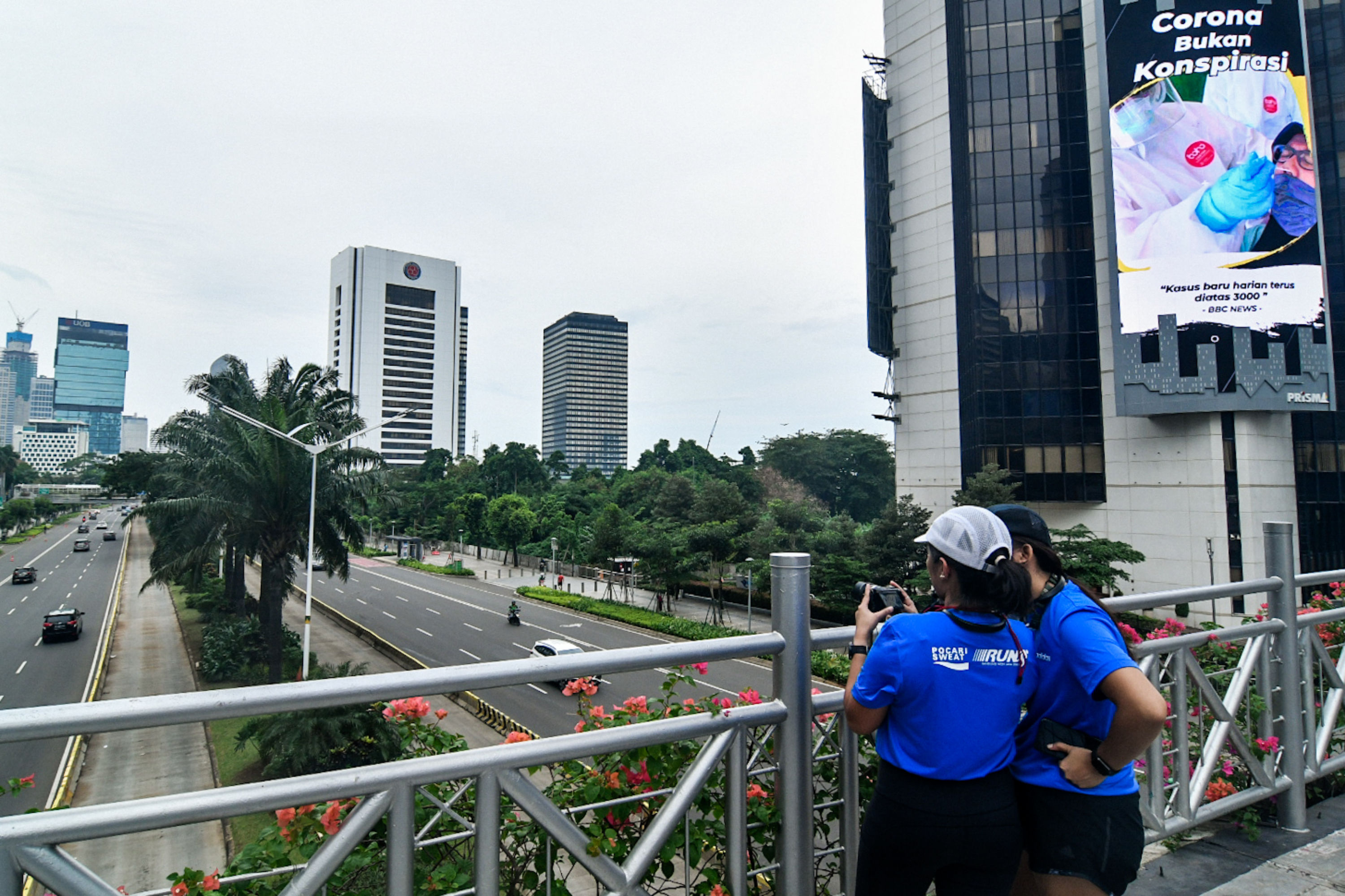 Warga berfoto di JPO tanpa atap kawasan Sudirman, Jakarta, Minggu (11/10). Pemprov DKI Jakarta kembali terapkan PSBB transisi 12-25 Oktober.